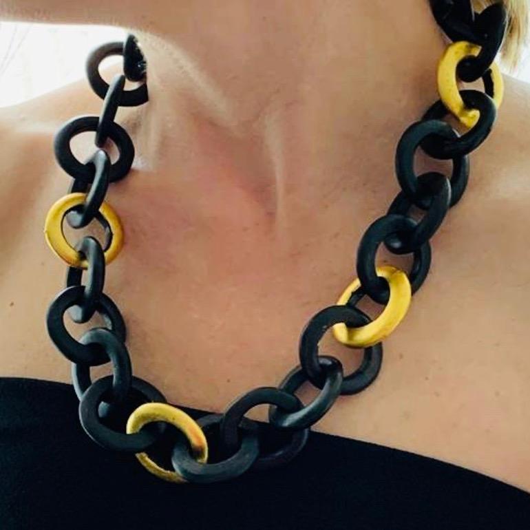 Necklace in ebony.
This beautiful precious wood necklace is made up of gold circles, some of which are gilded with gold leaf. The clasp is a keyboard.
Length: approximately 64 cm, width: 3.2 cm, thickness of a link: approximately 5.6 mm.
Total