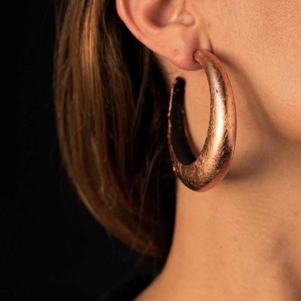 For pierced ears.
Earrings in ebony.
These hoops earrings are large, open and curved. They are plated with a thin leaf of copper on the outside. The hanging system is a silver butterfly.
Height: 3.5 cm, width: 13 mm, thickness: about 8