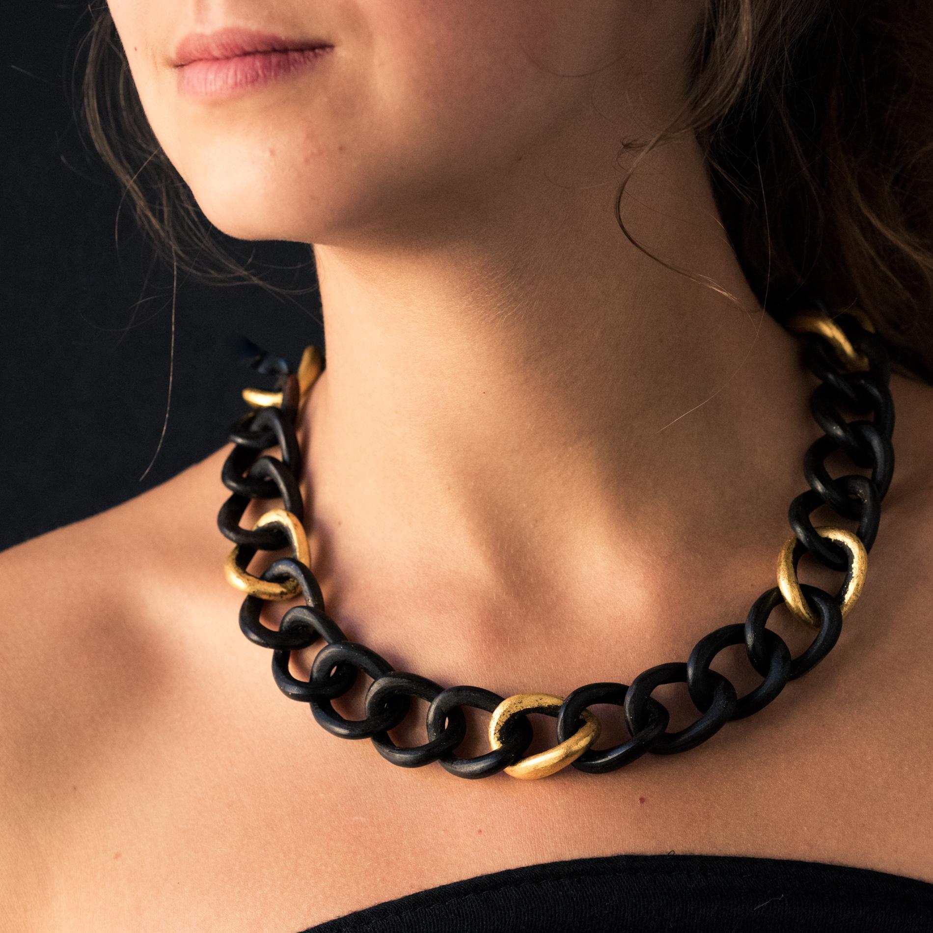 Necklace in ebony.
The mesh of this precious wood necklace is a gourmette link, with 5 links adorned with gold leaf. The clasp is a keyboard.
Length: 52.5 cm, width: about 2 cm, thickness: about 1 cm.
Total weight of the jewel: 42.4 g