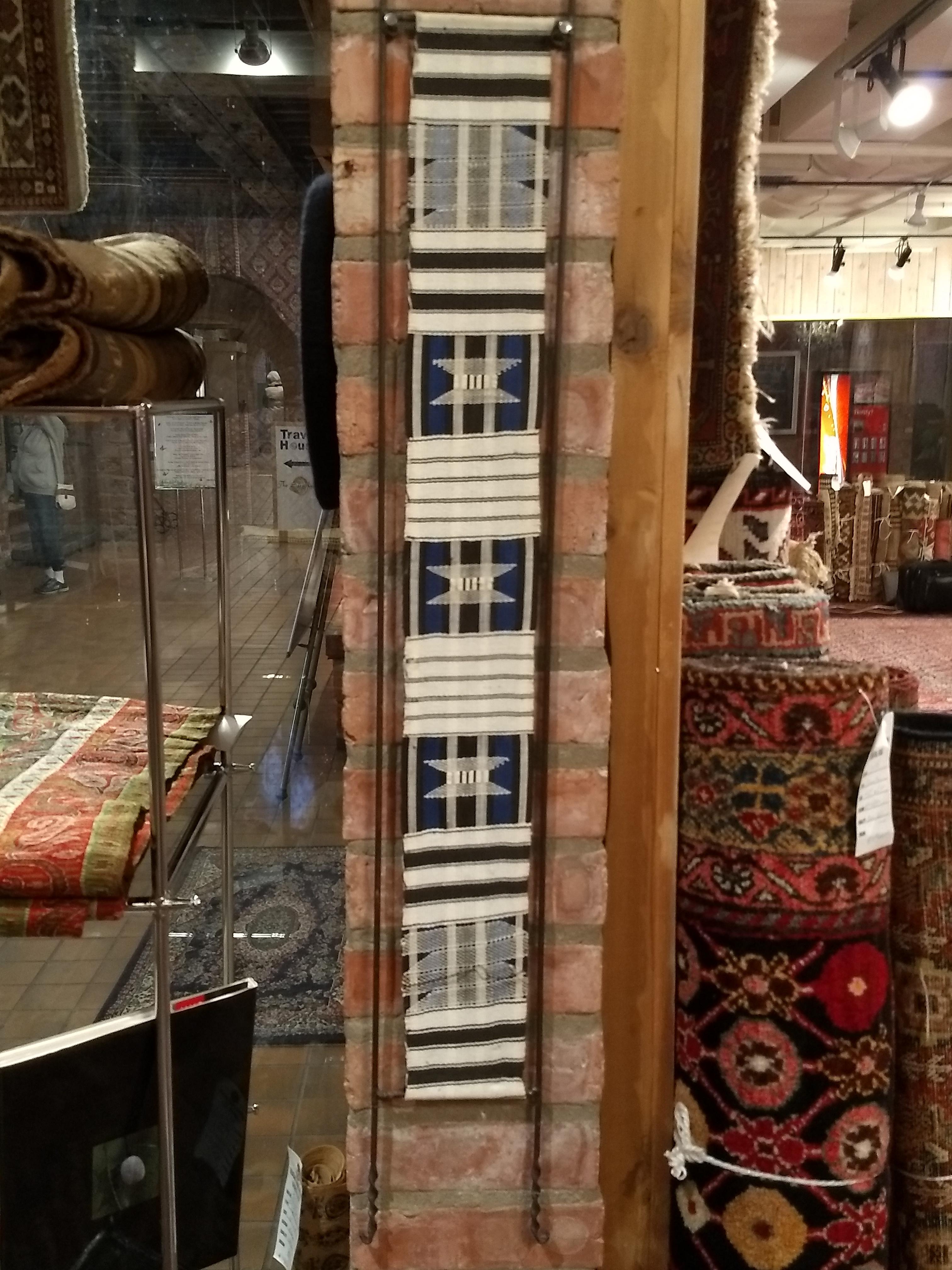 This exquisite vintage African tapestry, dating to the mid-1900s, features a flat-woven kilim textile hand-crafted using natural dyes in striking indigo blue and white. The alternating bands of geometric motifs and tribal patterns are meticulously
