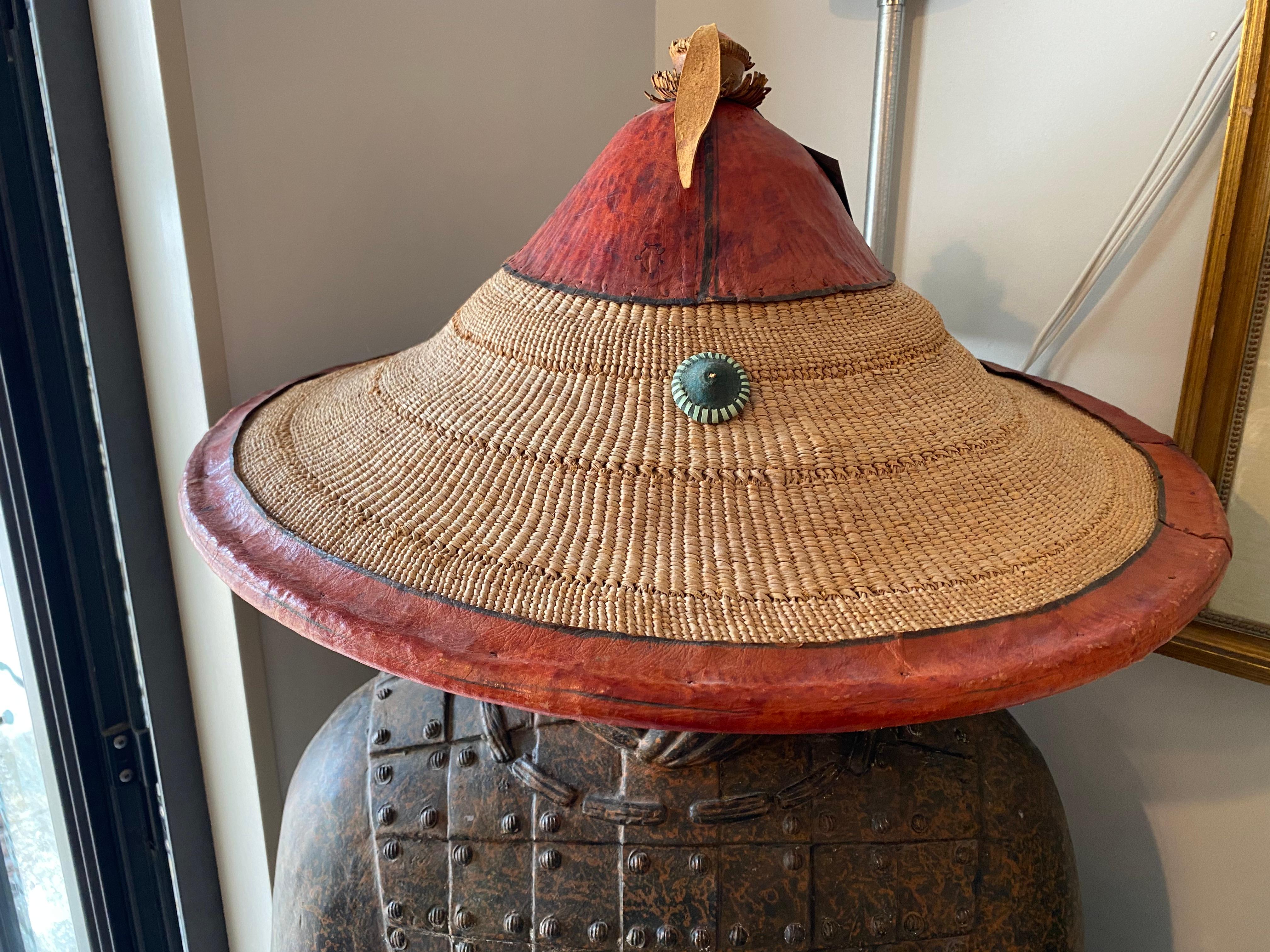 This African FULANI leather & woven Conical HAT is well made and very interesting having an orange trim and a medallion to the front in very good condition.