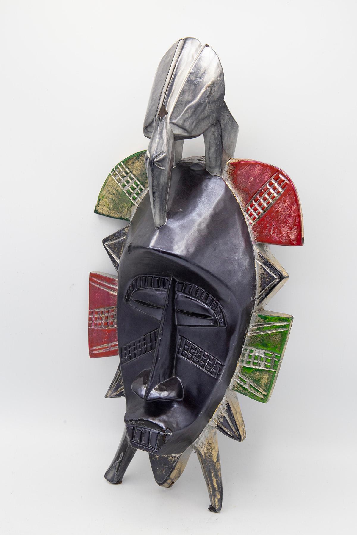 Contemporary African single mask created by the artist Bomber Bax.
The mask dates back to the early 1900s and was subsequently processed and painted in late 2022 by the artist.
The artist used special metallic paints to evoke a lunar effect and