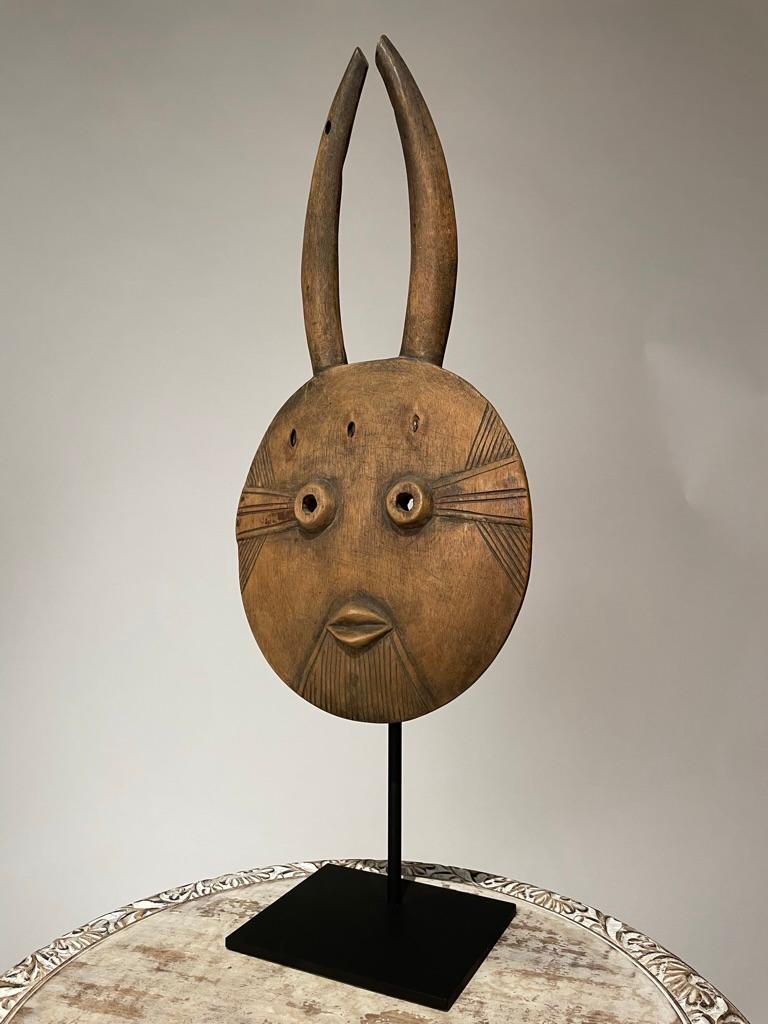 Masque africain hautement décoratif, sculpté à la main, dans le style d'un masque tribal Goli, peuple Baoulé, Côte d'Ivoire. Monté sur une base en acier sur mesure.

Dimensions : 23,75 pouces de haut (y compris le support) 9 pouces de large et 5