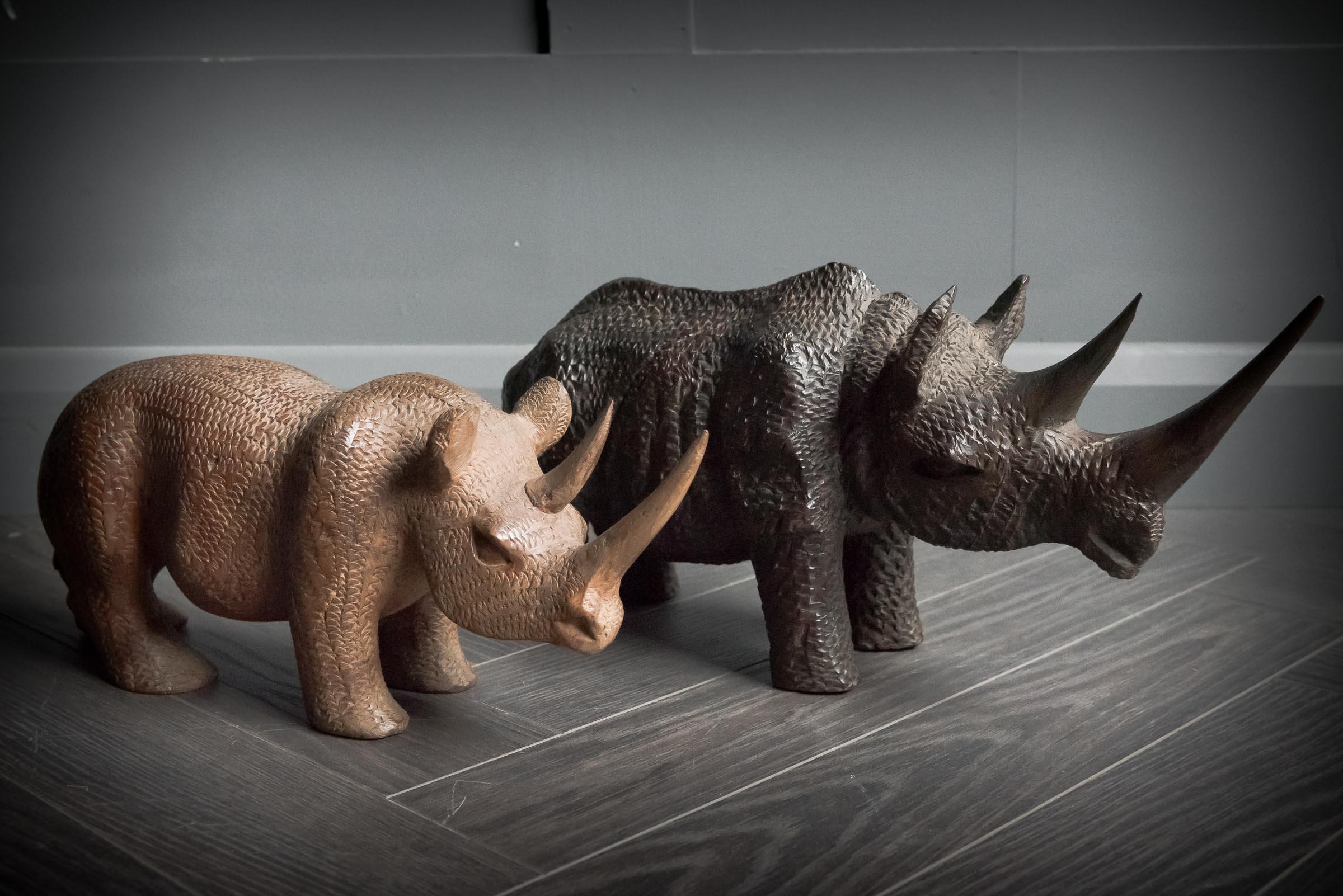 Charming pair of hand carved wooden rhinos, one white rhino and white black rhino.