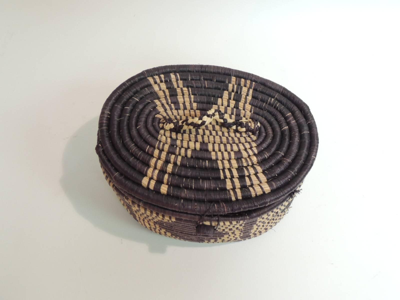 African handwoven oval artisanal basket with Lid
African handwoven oval artisanal basket with a lid made by women in Uganda. 
Artisanal basket with textured finish.
Size: 6 x 8 x 5.5 H.
 