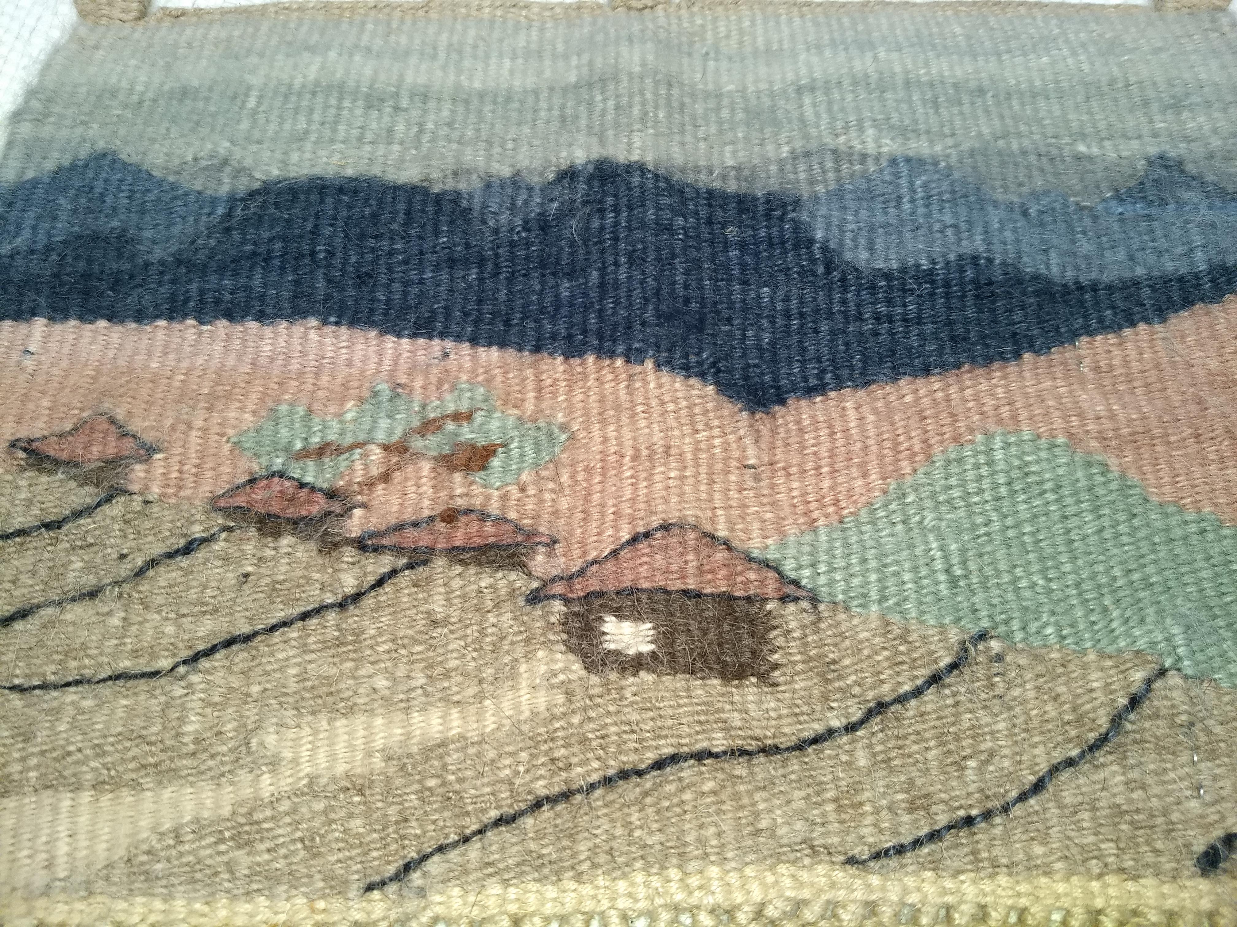 This African Handwoven Tapestry is a beautiful tribal art created by the artisans in the Kingdom of Lesotho, Africa.  The African Handwoven Tapestry depicts a village scene on the foothills and the mountains in the distance.    The use of the