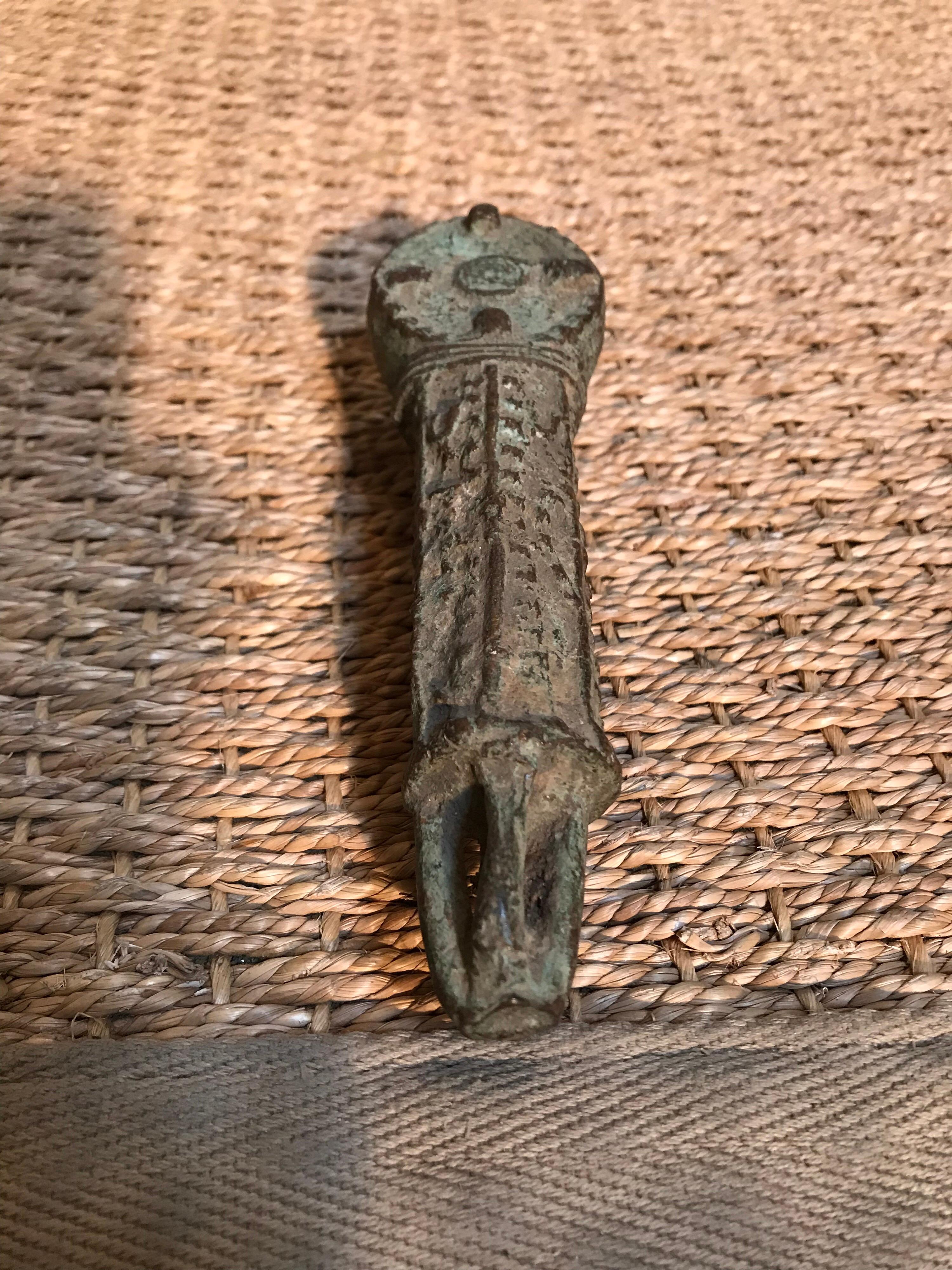 This 19th century harvest African currency is from the Ibo tribe in Nigeria. It looks something like an animal and reminds of a crocodile. One of the end sections is slatted so as to allow the user to tote the item around on a tether, displaying