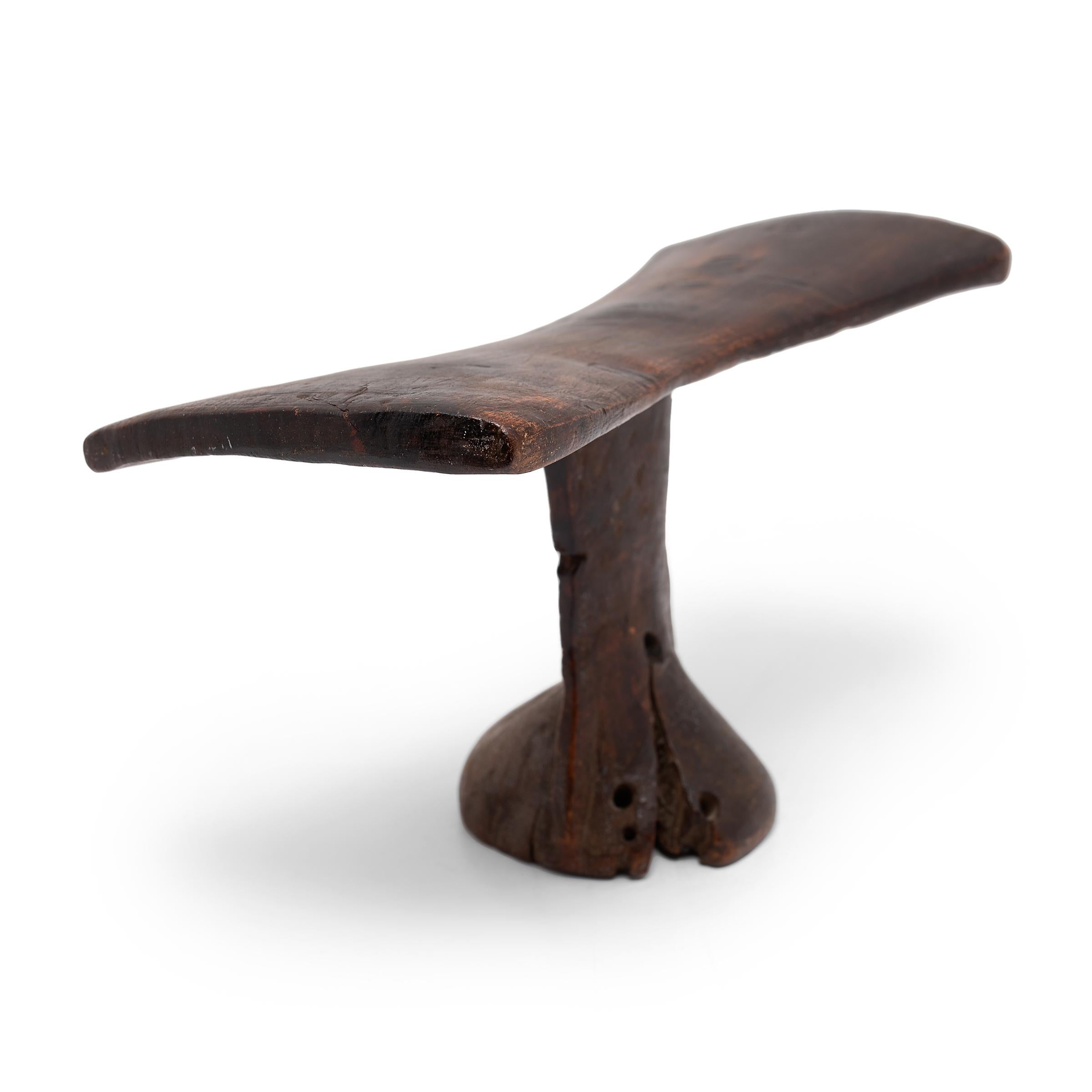 This headrest comes from 20th century Kenya, hand-carved from one piece of indigenous wood. Headrests held great value to North Western nomadic pastoral tribes of Kenya as they have a cultural custom of wearing elaborate coiffures. Headrests helped