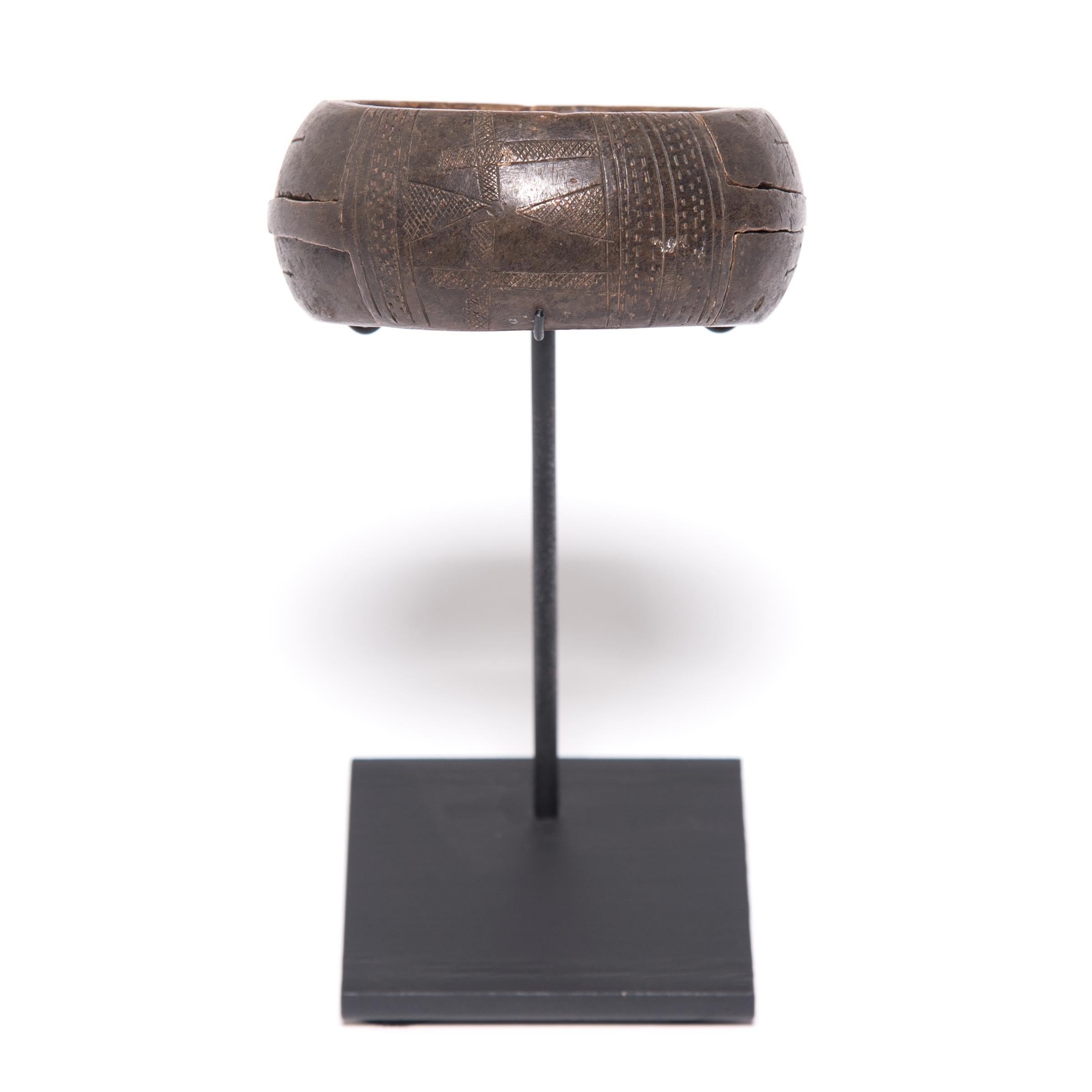La texture et la forme de cet objet sculptural nigérian en cuivre sont honorées par le temps. La géométrie complexe a été obtenue par un processus connu sous le nom de scarification. L'artisan traçait et retraçait méticuleusement ses sculptures pour