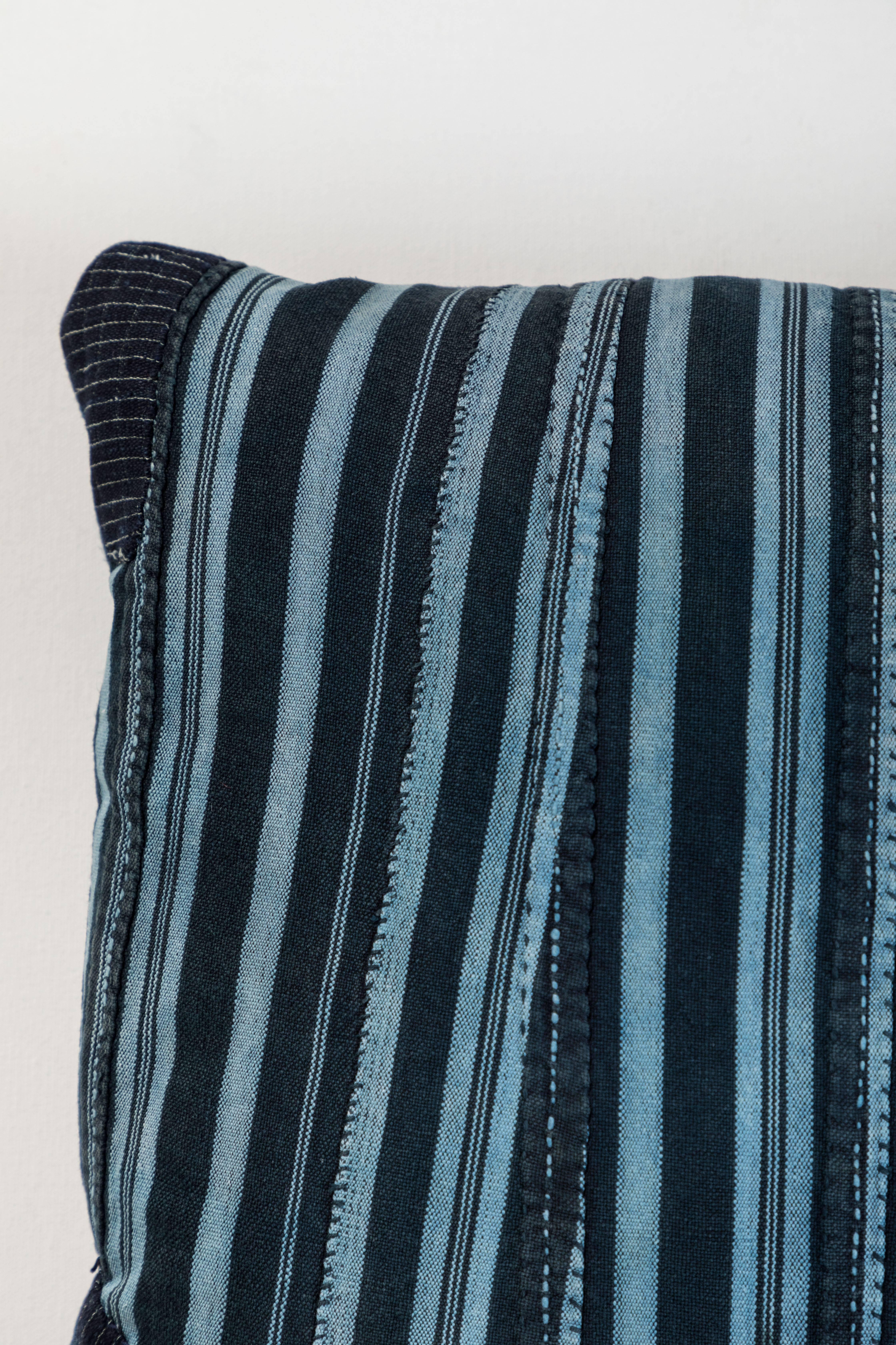 Pillow made using vintage Ashante textile. Handwoven in Nigeria by the Yoruba Tribe. Long strips of cotton hand woven on narrow backstrap looms.  Blue linen back, invisible zipper closure and feather and down fill. 

