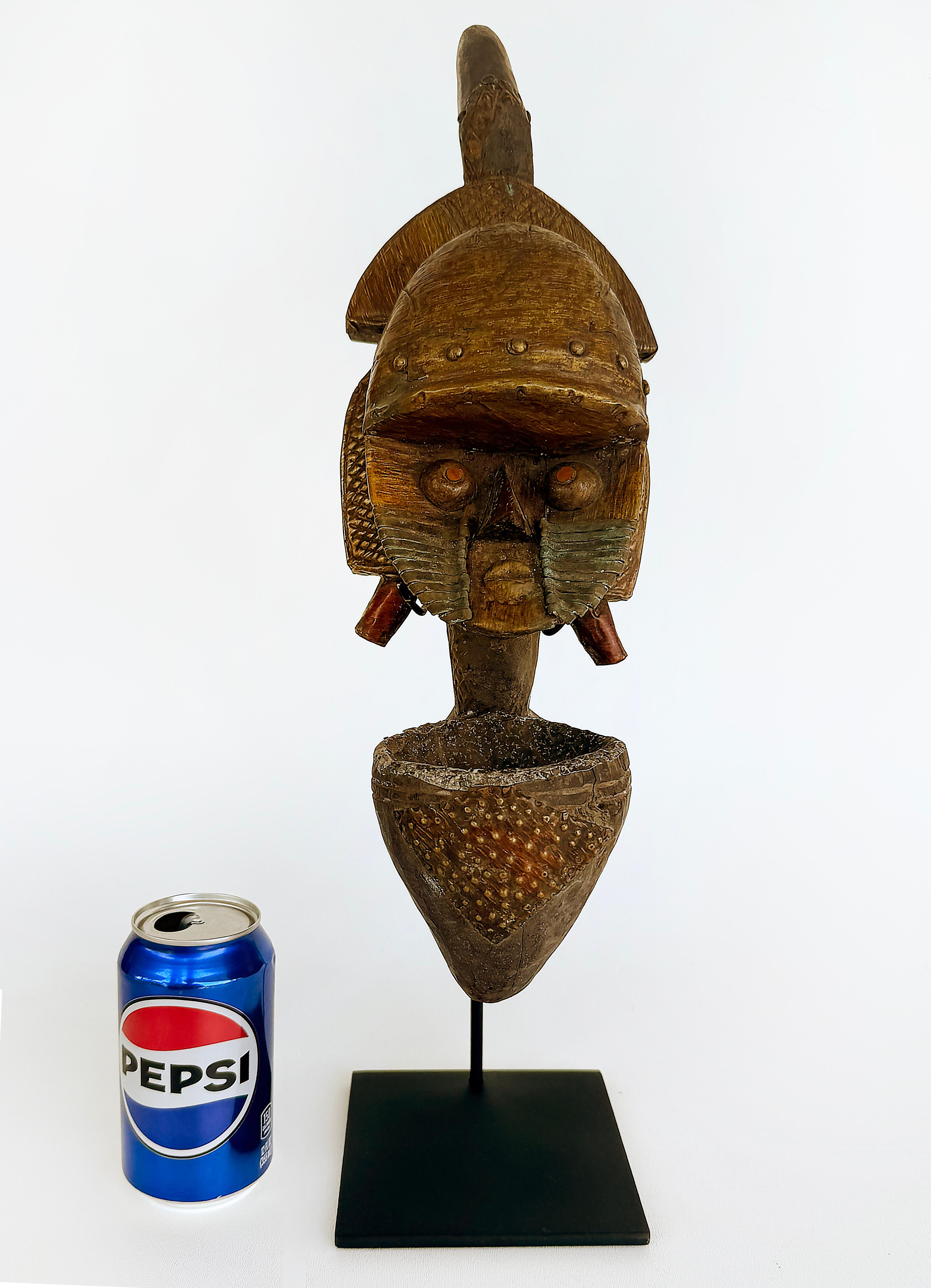 Peuple africain Kota, Gabon Pipe reliquaire en métal sculptée sur pied, 20e siècle

Nous proposons à la vente une pipe reliquaire africaine en bois sculpté à la main et en métal martelé sur pied, provenant du peuple Kota du Gabon.
La pipe a été