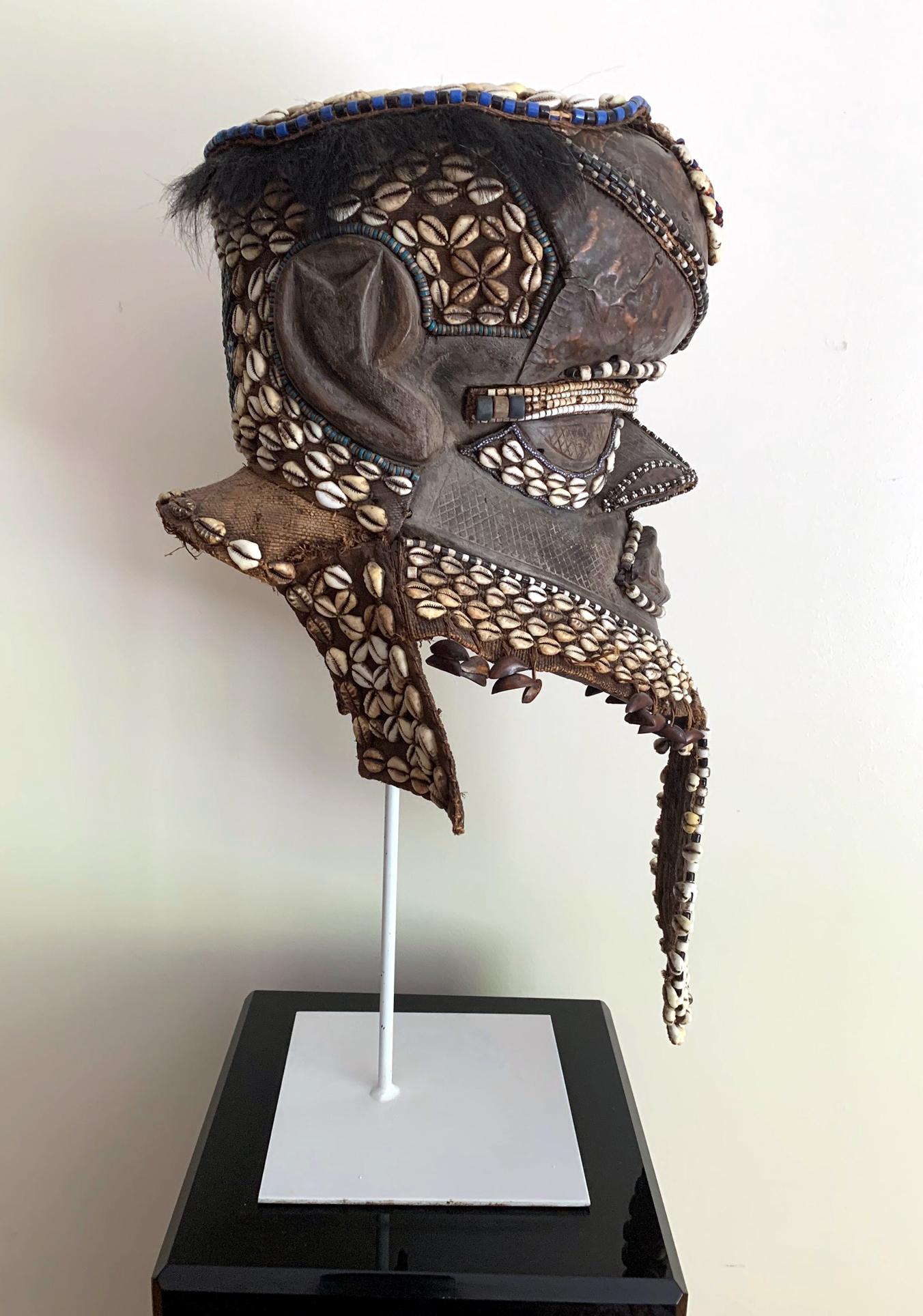 Maschera a casco nota come Bwoon, proveniente dalla tribù dei Kuba nella regione del Kasai, Repubblica Democratica del Congo, Africa centrale, circa metà del XX secolo. La maschera in legno intagliato era decorata con piastre di rame sul viso e