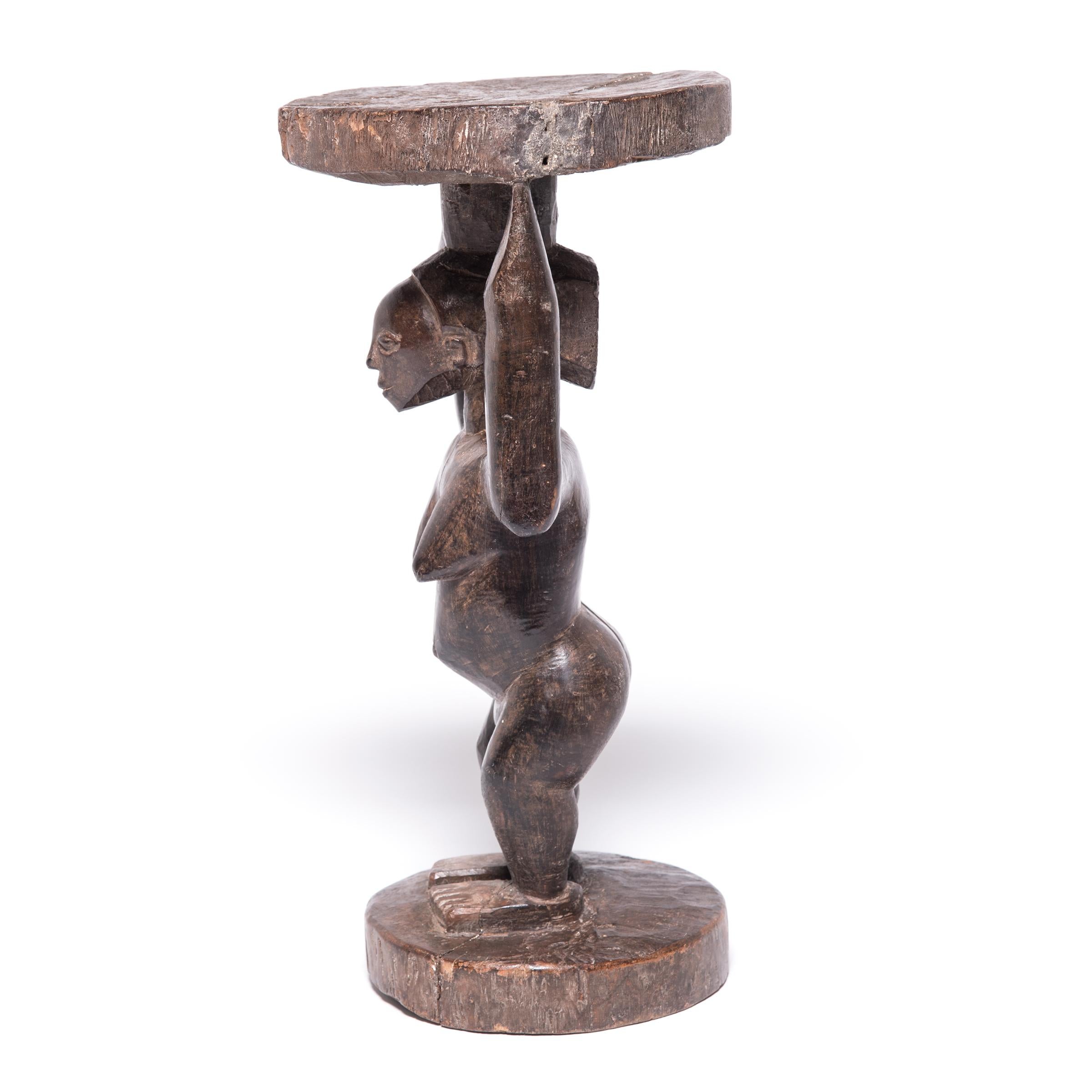 Ce tabouret du peuple Luba du Zaïre est représentatif de leur style classique. Un simple tronc d'arbre a été sculpté en colonne, puis approfondi jusqu'à ce que la silhouette robuste d'une femme apparaisse. Elle soutient le siège circulaire,