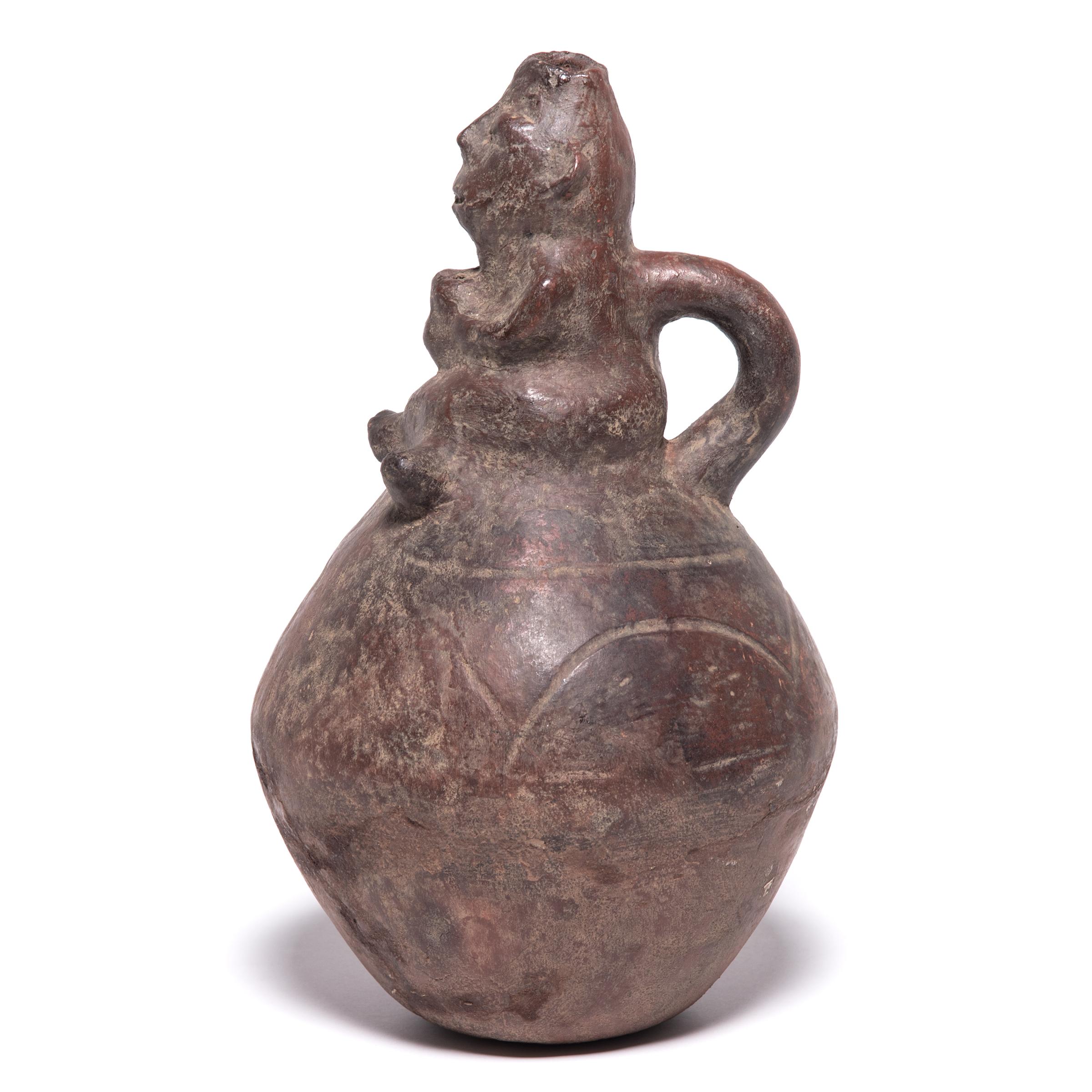Receiving guidance from tribal ancestors was a central aspect of the Luba people's spiritual practices. This ceramic spiritually significant vessel is topped with a crossed leg figure whose head has an opening critical for a divination ritual. Known