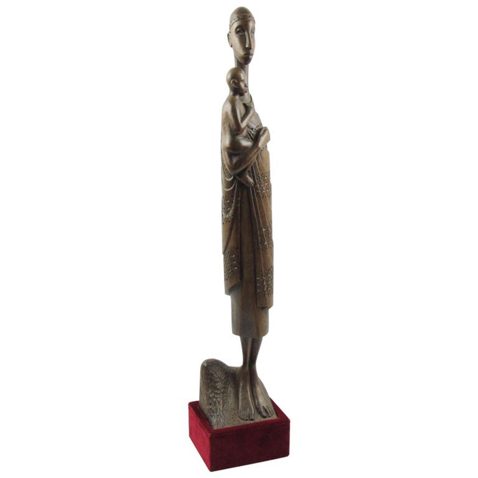 L'artista Ndatite Ilo, della tribù Tutsi del Ruanda, ha scolpito questa splendida statua africana in legno. Questa opera d'arte unica raffigura una bellissima donna nera, una Madre o Madonna, che porta in braccio un bambino. La spettacolare forma a