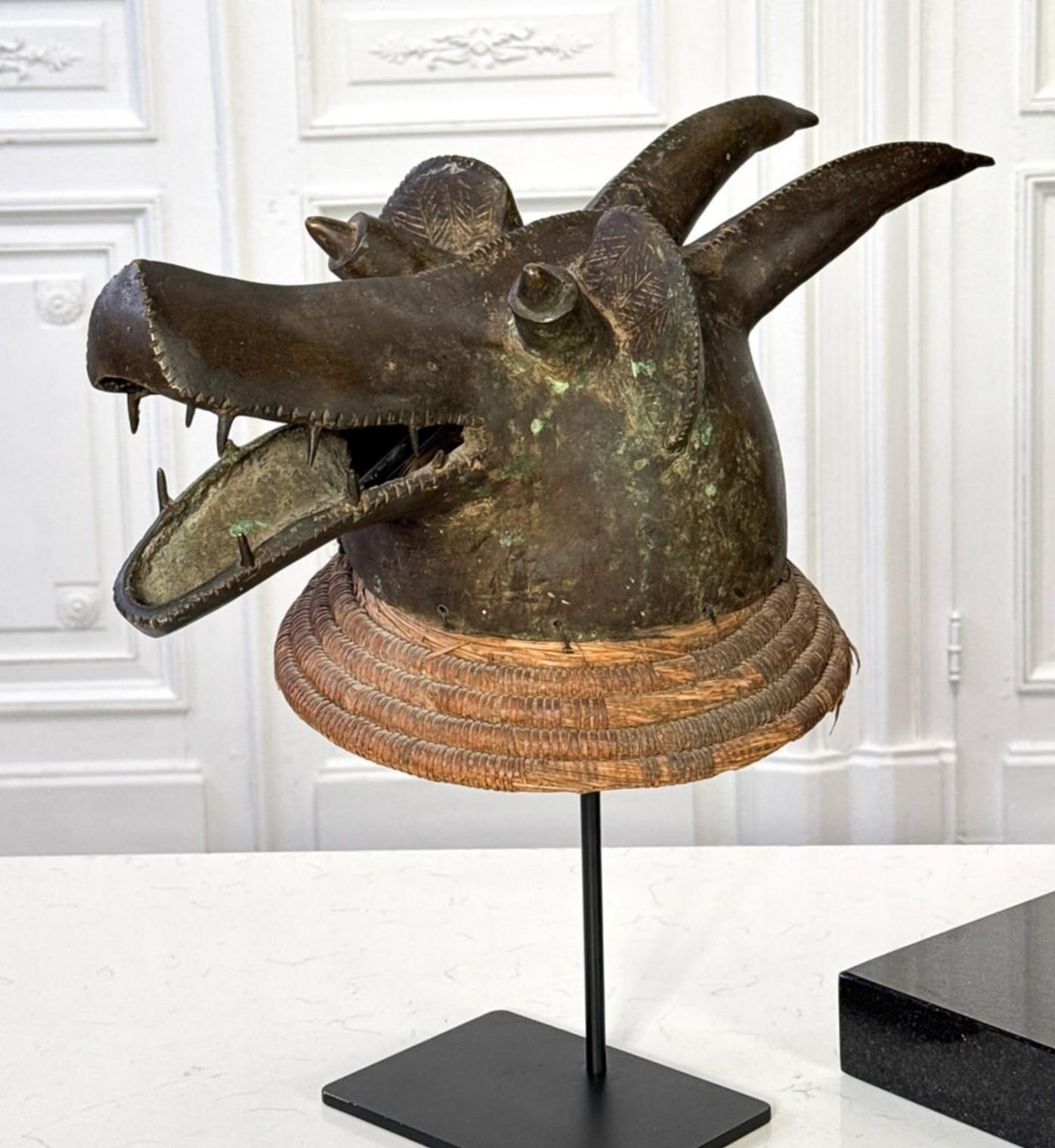 Una máscara de cabeza de perro Mambila suaga extraordinariamente rara y fina 

- Probablemente Meseta de Mambilla, Nigeria /Camerún, praderas de África Occidental 
- Bronce, fibras naturales de rafia 
- Edad desconocida

Obra de calidad excepcional