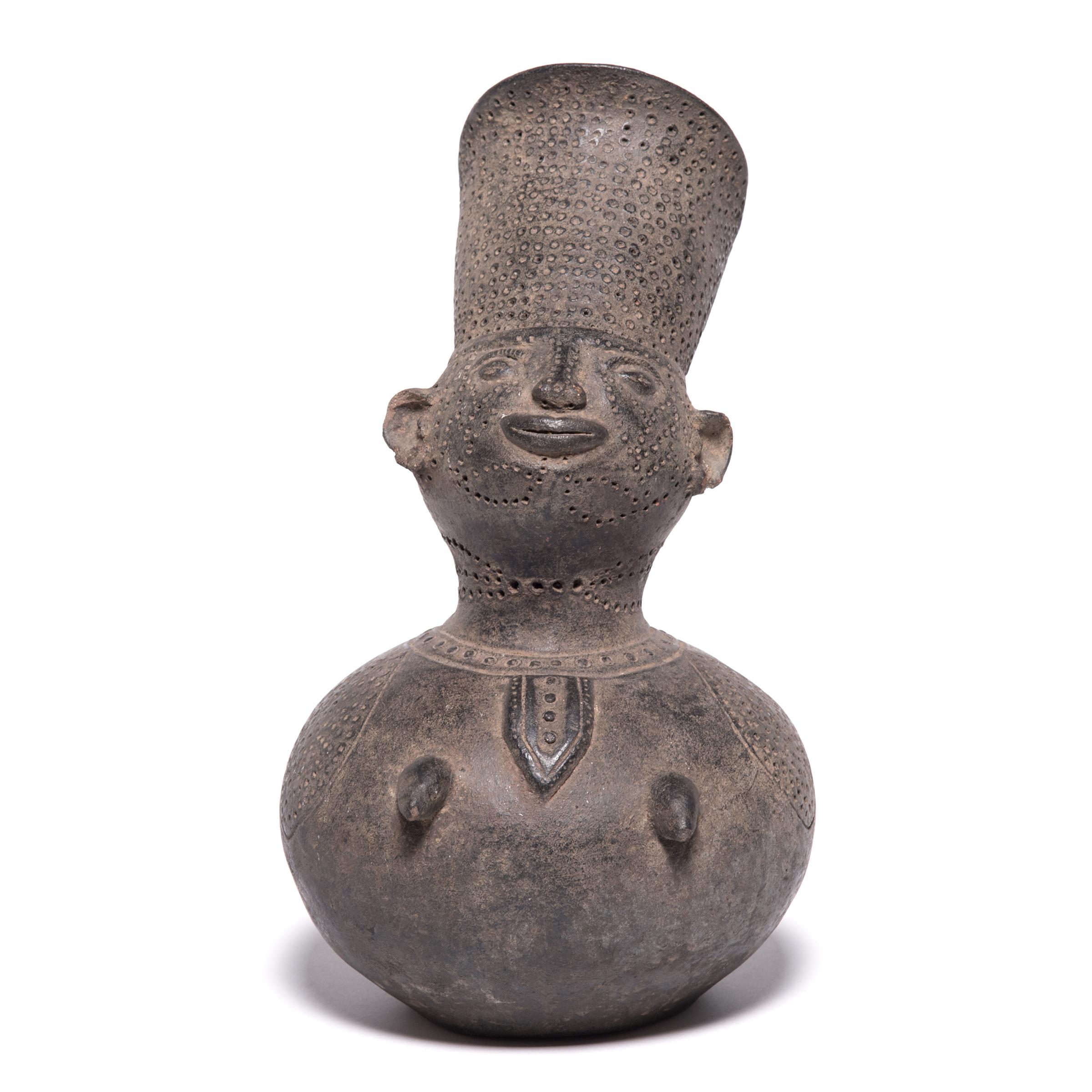 The Mangbetu people focused on highly realistic art forms. This ceremonial jug seamlessly transitions between figurative and abstract forms, from the spout formed to look like hair, to the expressive face, and down to the rounded, gourd-shaped base.