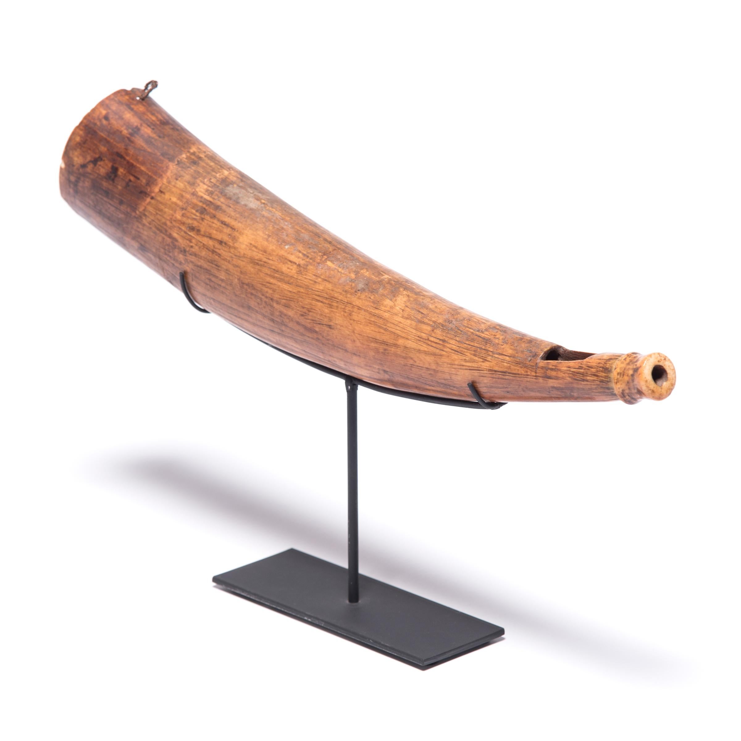 Crafted from a hollowed buffalo horn, this graceful object is a side-blown instrument known as a mbiu, used within Swahili-speaking groups of east Africa. Unlike the ornate siwa horns held by chiefs or kings, often of lavishly carved ivory, the mbiu