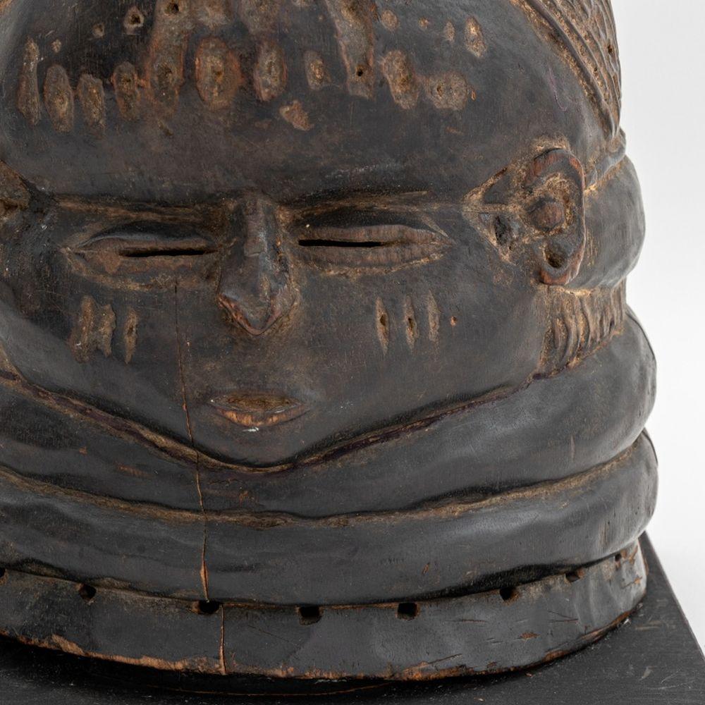 Maschera africana Mende con elmo in legno intagliato, insieme alla documentazione della Segis Gallery, su una base quadrata in legno ebanizzato. Complessivamente: 16