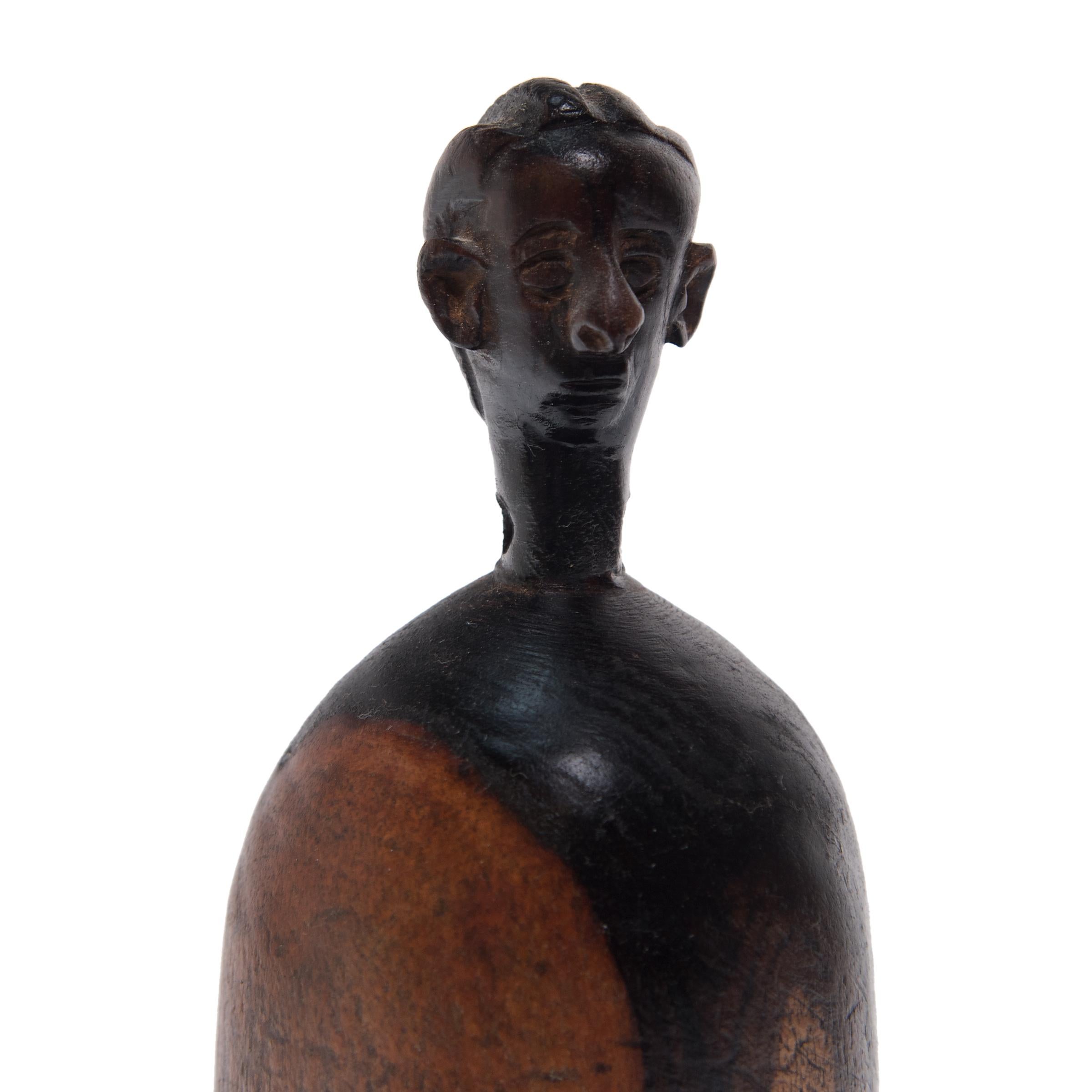 Diese geschnitzte Puppe, die wie ein echtes Kind gehätschelt wird, gehörte einst einem jungen Mädchen aus dem Volk der Namji im Nordwesten Kameruns. Die Figur, die von ihrer Besitzerin überallhin mitgenommen und liebevoll mit Perlen oder Kleidern