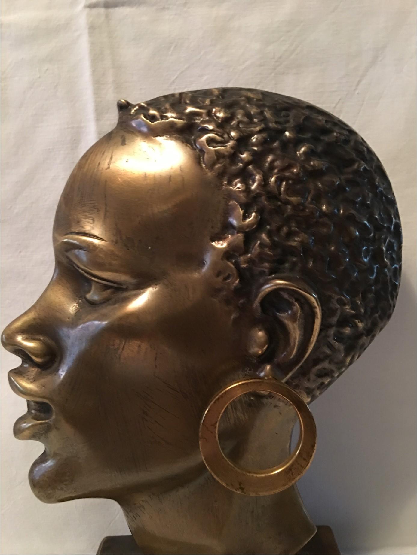 A very detailed lovely brass bust of an African Native sitting on a marble base. From the design shops of Hagenauer in Austria from the 1950s era. With a nice aged patina.