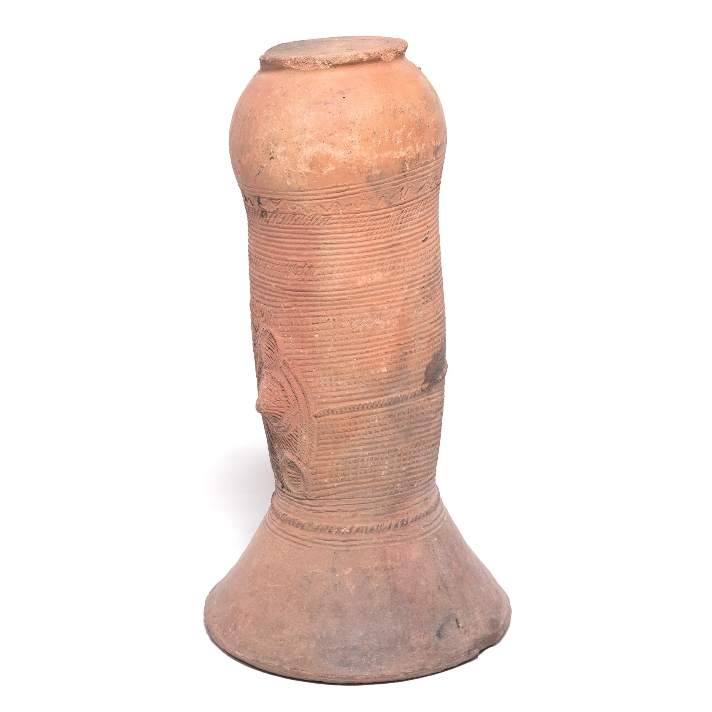 The Nupe people of Nigeria were touted as some of the finest ceramicists in Africa. Everyday objects, like this elegant, cylindrical vessel support, received detailed attention. This flaring terra cotta form would have been buried halfway in the