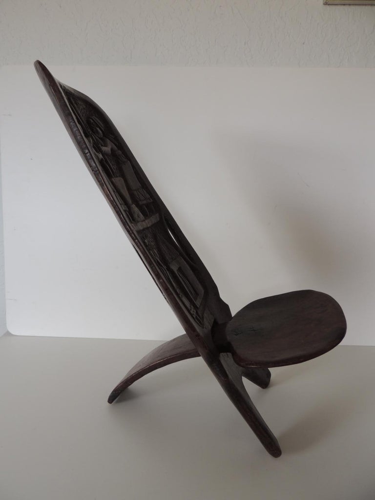 African palaver child's folding chair.
Hand carved chair depicting women at work in the back.
Rounded seat.
Size: 21