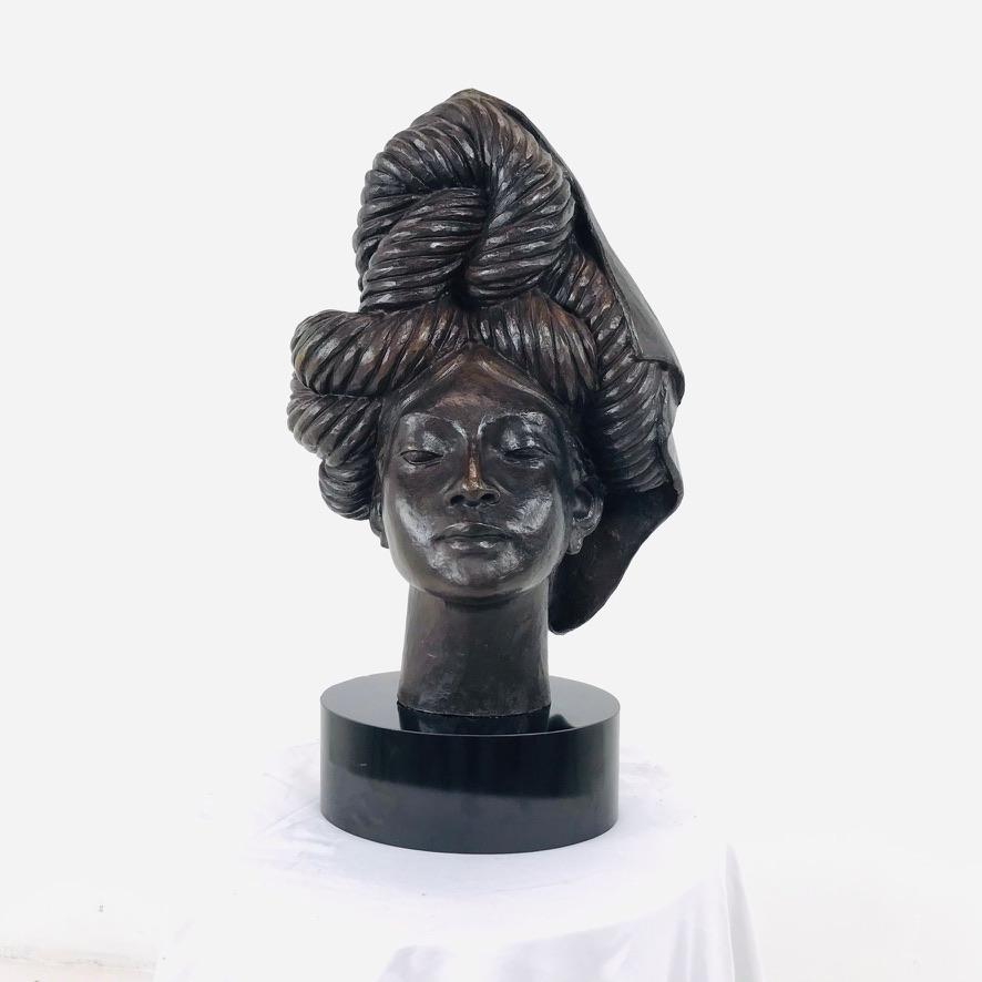 This beautiful depiction of an elegant African lady was hand sculpted in detail by the artist. Sits atop black lacquer base.