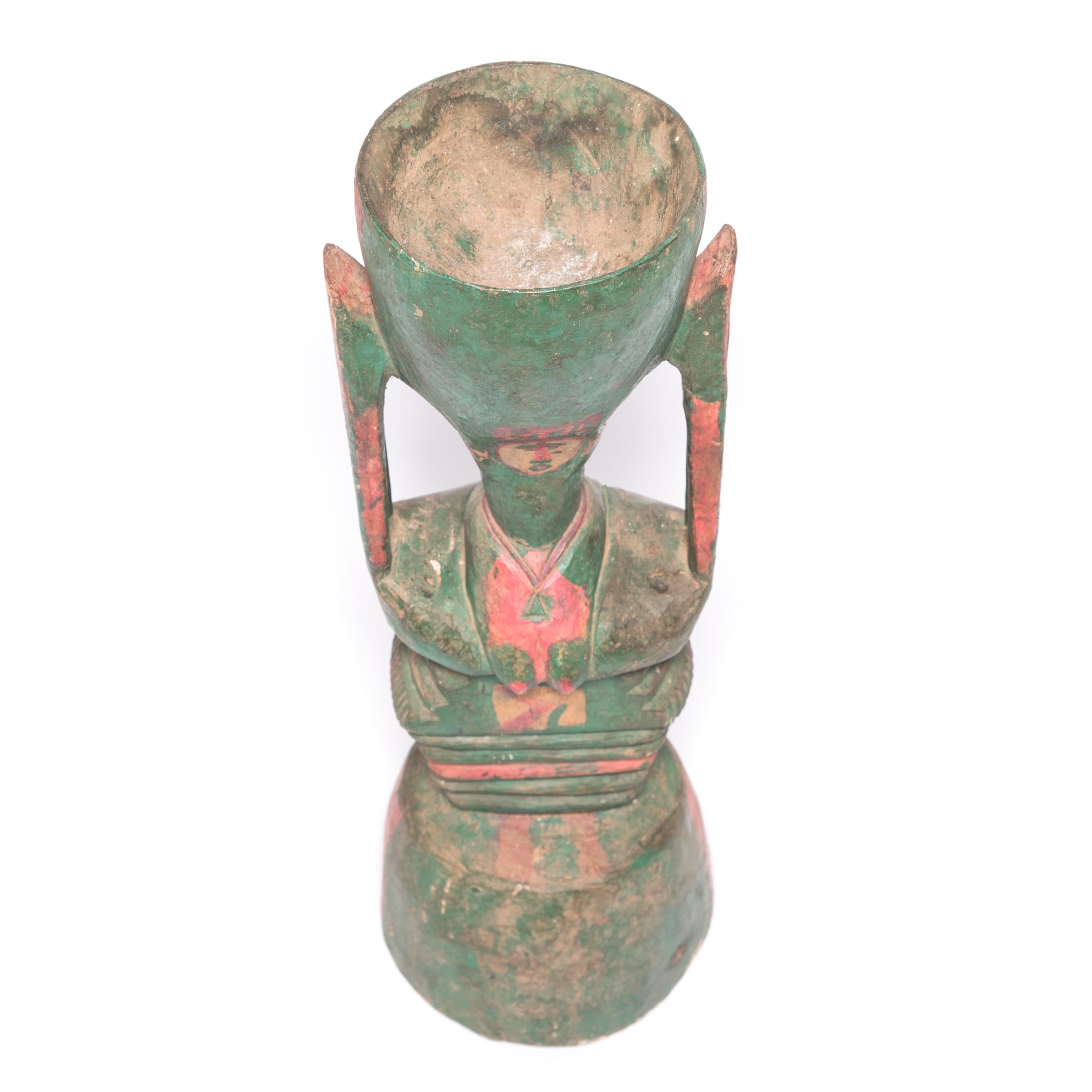 Astratta e scultorea, questa forma in legno dimostra il fascino senza tempo dell'arte africana. Intagliata a mano a forma di clessidra, l'insolita figura è in realtà un mortaio per macinare, composto da un piatto rotondo sollevato da una base