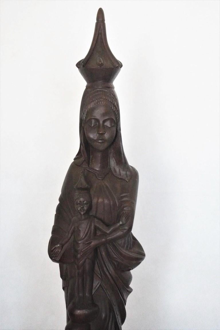 Sculpture africaine en bois de rose du milieu du siècle, merveilleusement sculptée à la main, représentant la Vierge Marie avec l'enfant Jésus, avec de grands détails et un beau visage.
Mesures : Hauteur 21,25