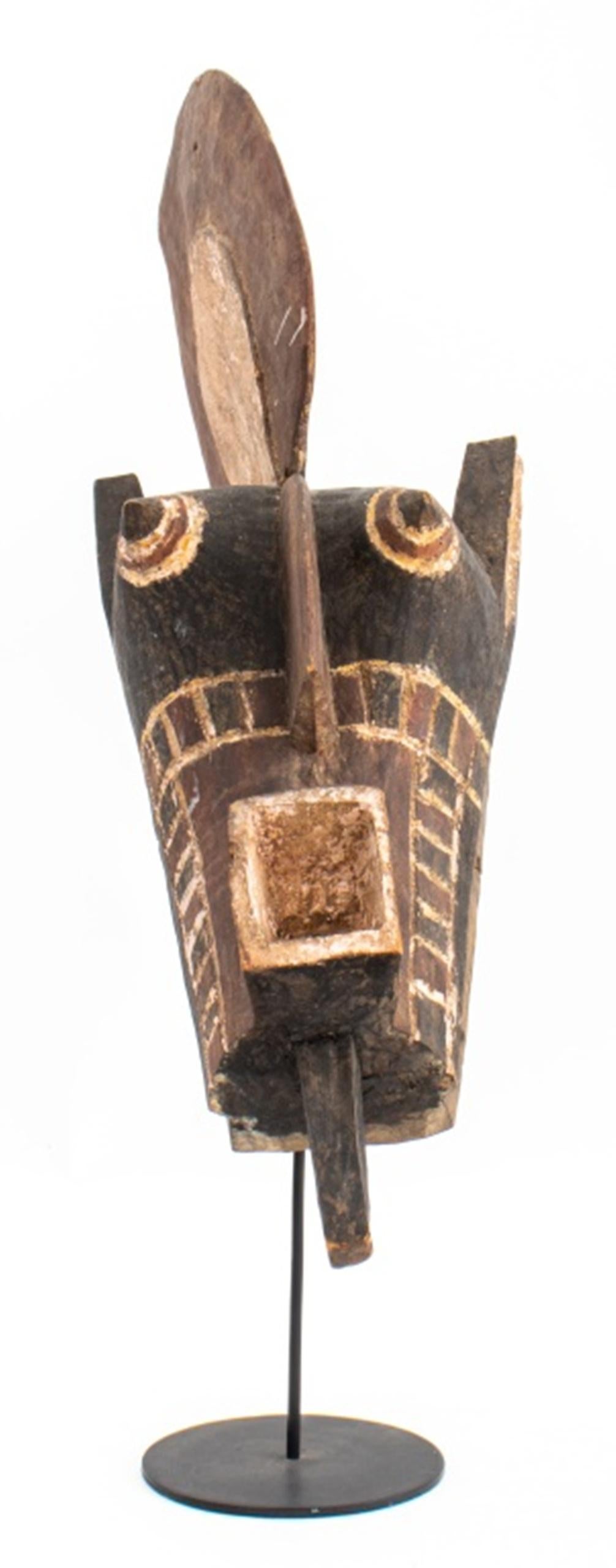 African Tribal mask, likely Sognye peoples of the Democratic Republic of Congo, with square mouth and protruding eyes, and fan comb to crown, with custom stand.

Dimensions: 27