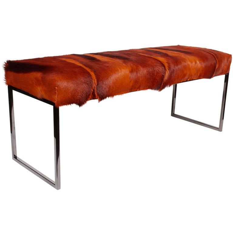 Exotic African springbok bench in hues of burnt orange. Mid-Century Modern design with streamline base in black chrome metal. Hand-dyed and comprised of several hides featuring multiple spine details. Excellent accent piece for any room.