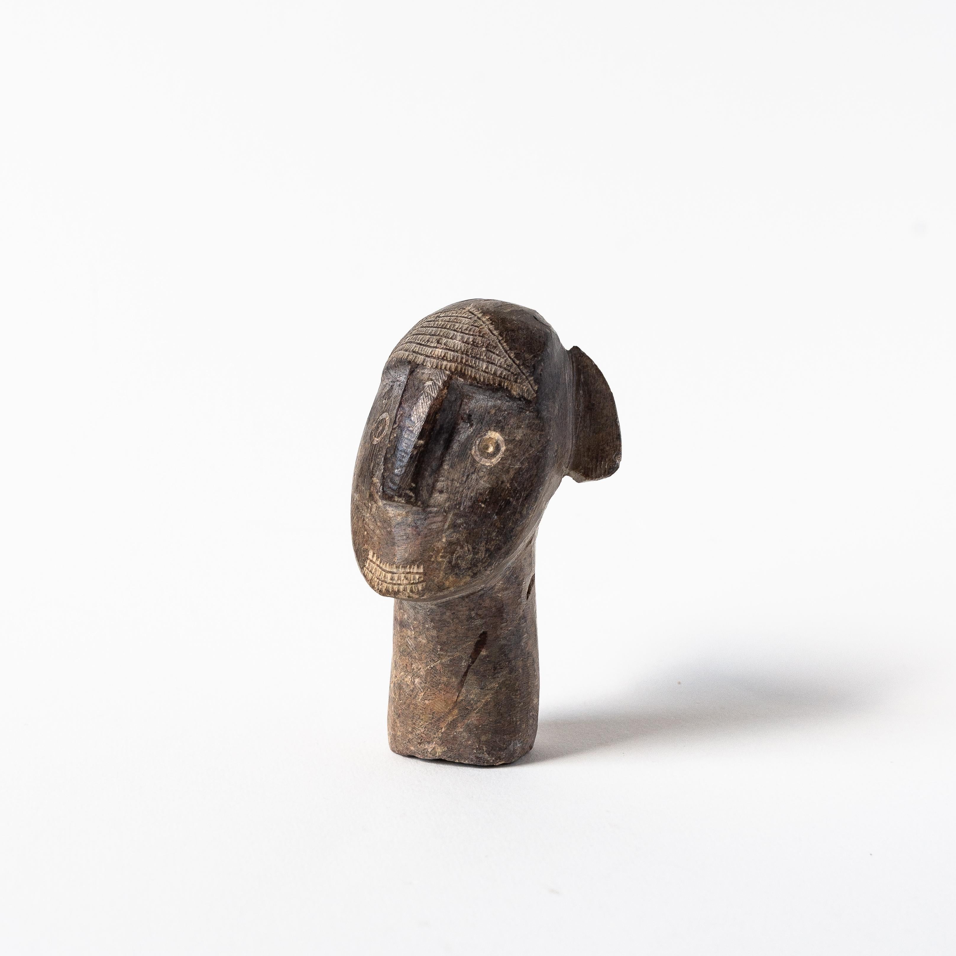 Sculpture africaine en pierre, buste d'homme ou masque, années 1960.

Petite statuette africaine en pierre, d'une hauteur de 11 cm, représentant la tête et le cou d'un homme, ressemblant à un masque traditionnel. 

La pierre est lourde, dense et