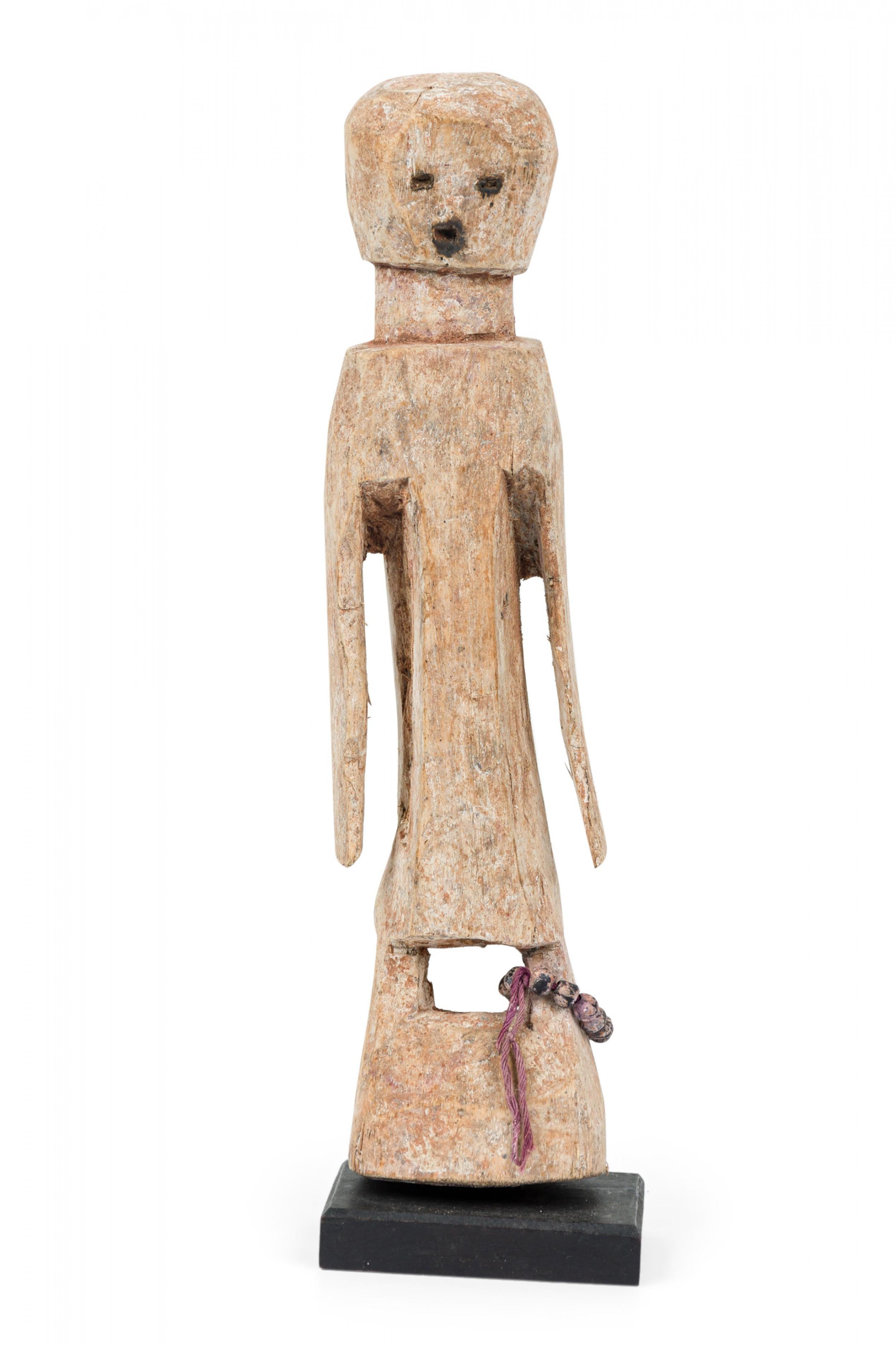Figurine Legba Aja (déesse de la guérison, des herbes et de la connaissance) en bois sculpté du Togo du 20e siècle, de style minimaliste, avec un collier de perles enroulé autour de sa jambe gauche, montée sur un socle rectangulaire. (Littérature :