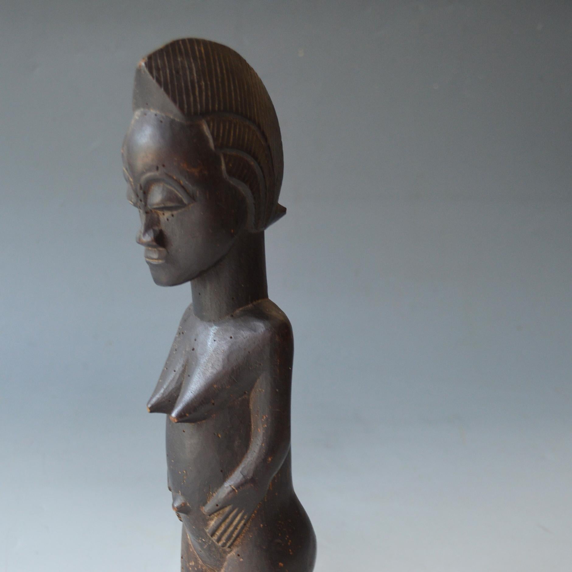 A fine  Baule female figure
Standing leaning forward with serene expression with hands on abdomen
Period: early 20th century
Condition: Old Insect holes and minor damage
Measures: H 32   
Ex  Hungarian collection.