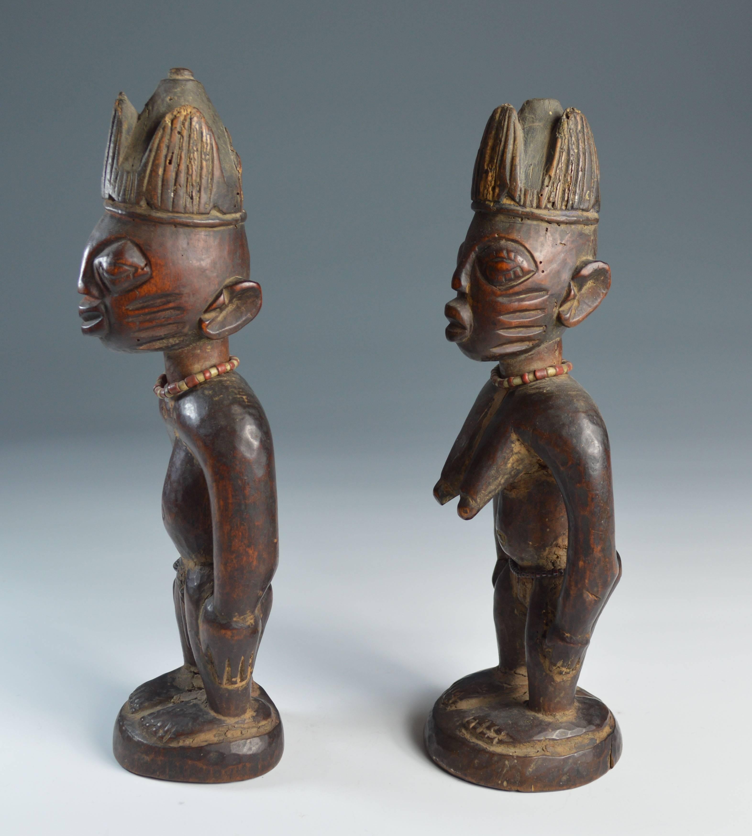 A fine pair of ere Ibeji figures from llorin region Nigeria.

A very fine old pair of male and female Yoruba ibeji figures with beaded necklaces facial scarification and crown type headdresses 

Showing fine aged patina and encrusted with cam wood