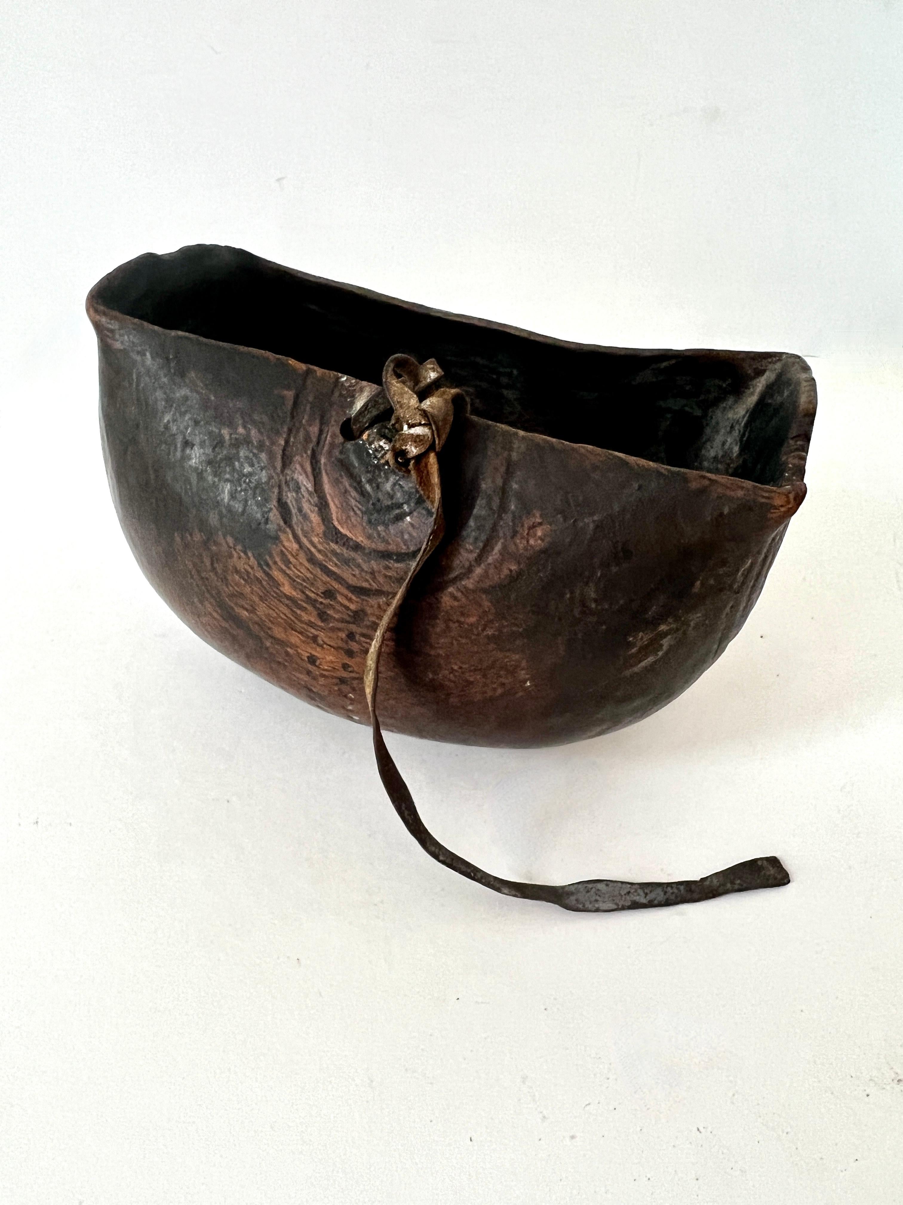 Hand-crafted and Hand-made in Africa.  The bowl is rare and beautiful, an art to transform the piece into this lovely town with etchings and leather strap - the design and African design are wonderful making each piece a one of a kind by the