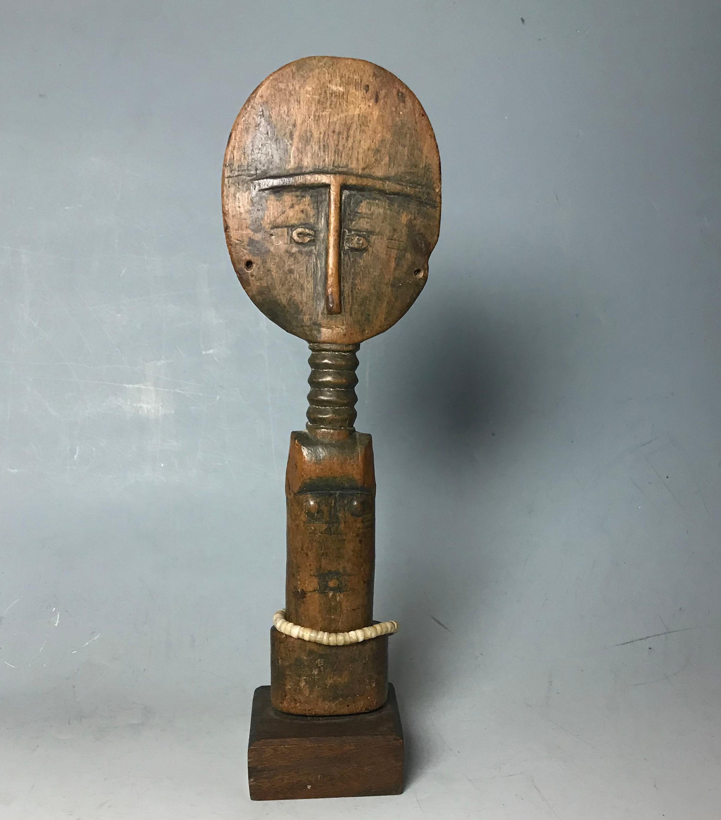 A fine Old Ashanti fertility Doll Akua'ba figure.
 
A aged figure with honey patina disc shaped head with T shaped features, carved in shallow relief, the upper body with ridged neck, old label on back.
Measure: height 31 cm.
Ex UK