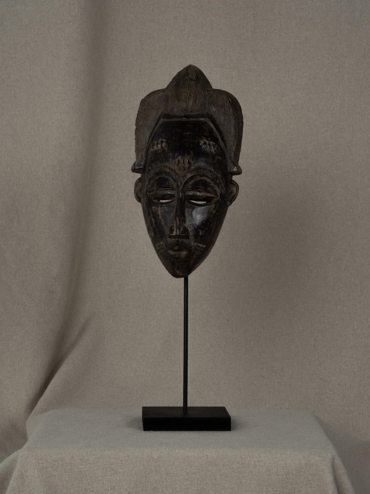 Il s'agit d'une pièce de collection qui représente la richesse de l'art africain. Masque baoulé en bois massif, fabriqué à la main, utilisé dans les danses tribales et diverses cérémonies traditionnelles. Le masque porte sur le front et les joues