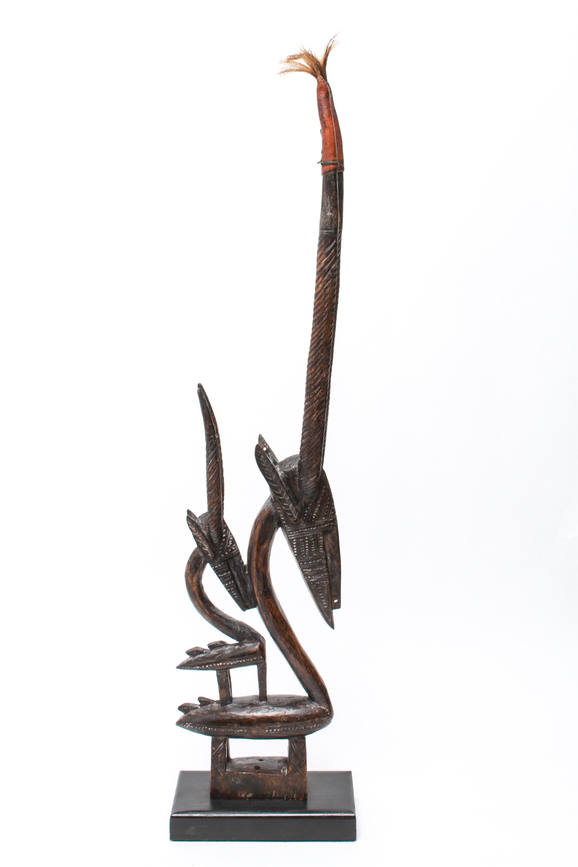 Tribal West African Bambara headdress in carved wood. The piece depicts an antelope with offspring, referred to as 