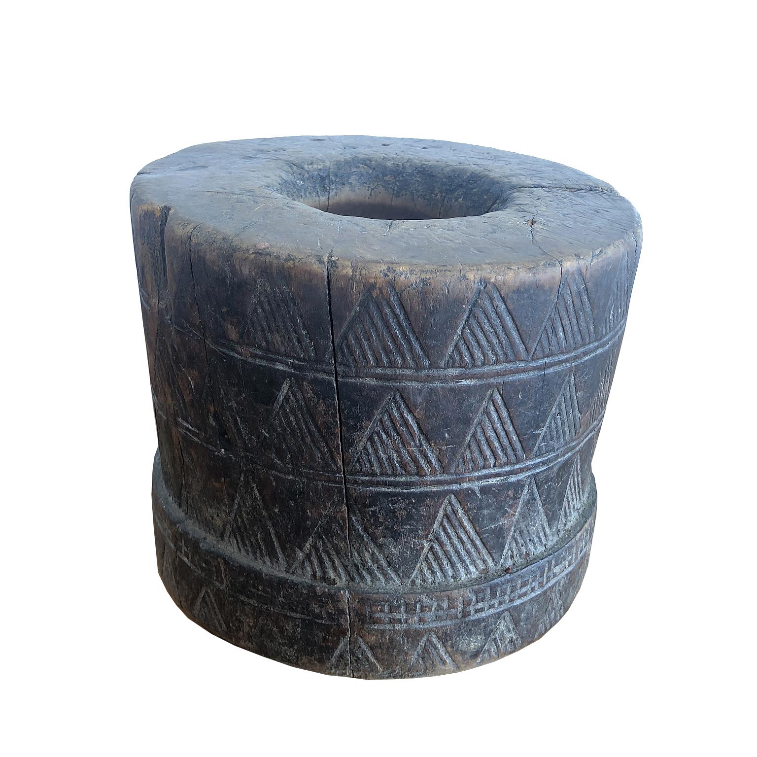 This fine African mortar was made and used by the Kaffa people in Ethiopia to grind coffee beans. Carved out of a solid block of wood and decorated with incised geometric carvings, it served as a utilitarian object in everyday tribal life and was