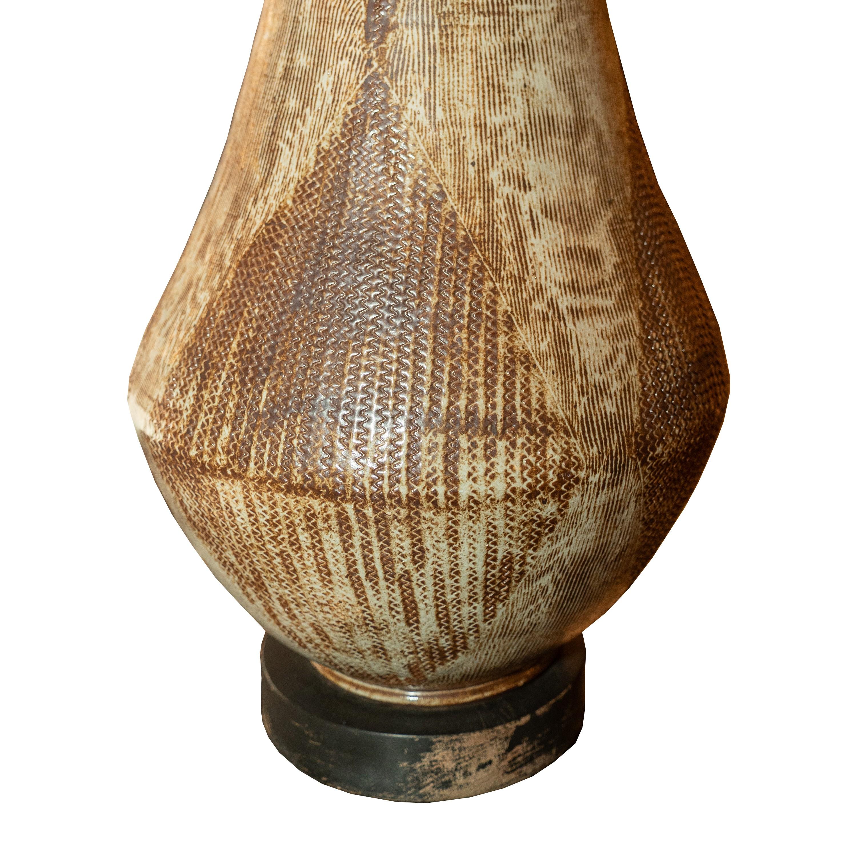 
Lampada in ceramica di ispirazione tribale africana su base in legno, fine del XX secolo, nei toni tenui della terra.