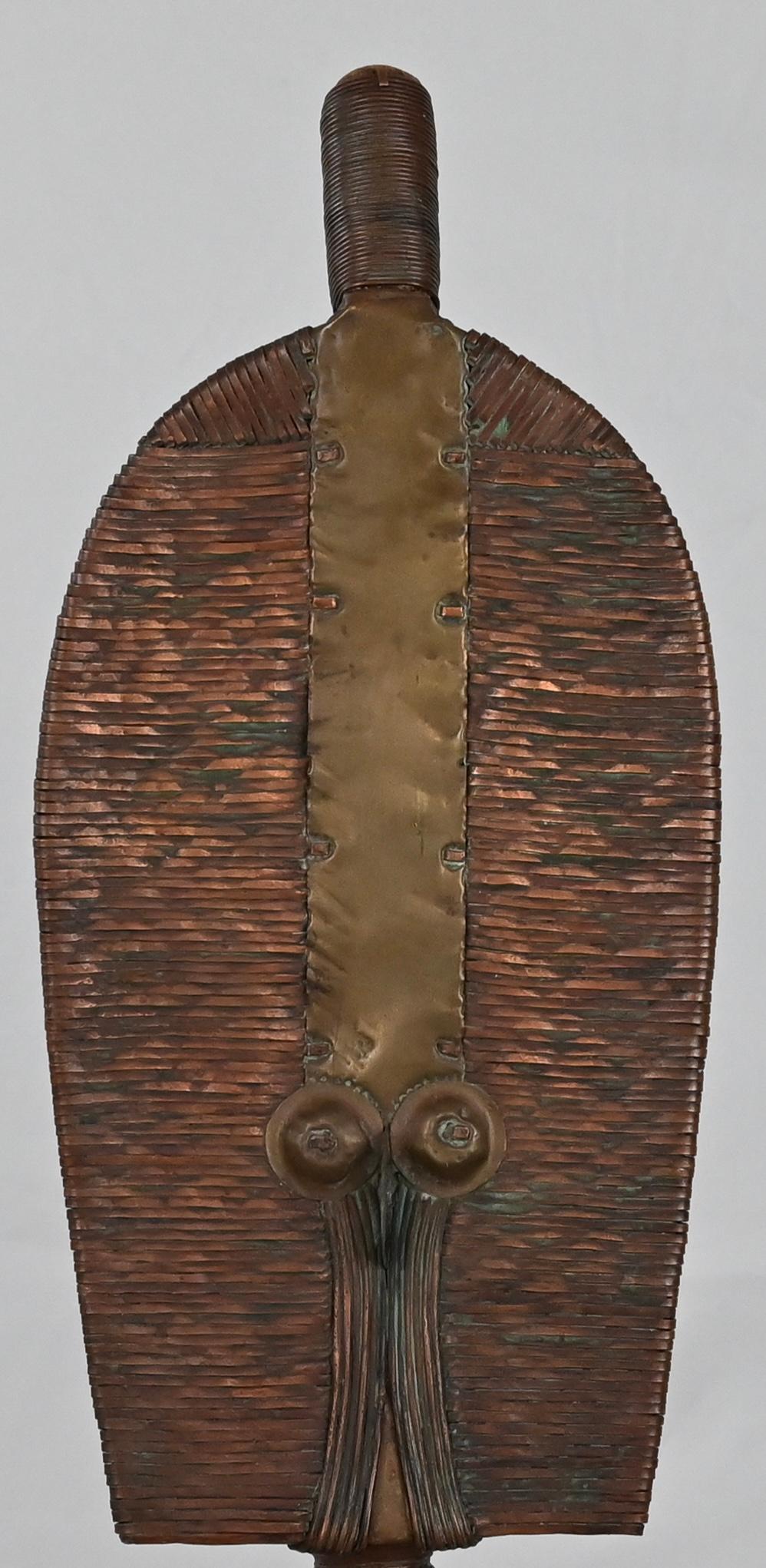 A fantastically hand-crafted piece by the Kota (or Bakota) tribe who are located in the northeastern region of Gabon. This figure, which is a Mahongwe reliquary figure as exhibited with its truncated almond-shaped face, is made of wound copper,