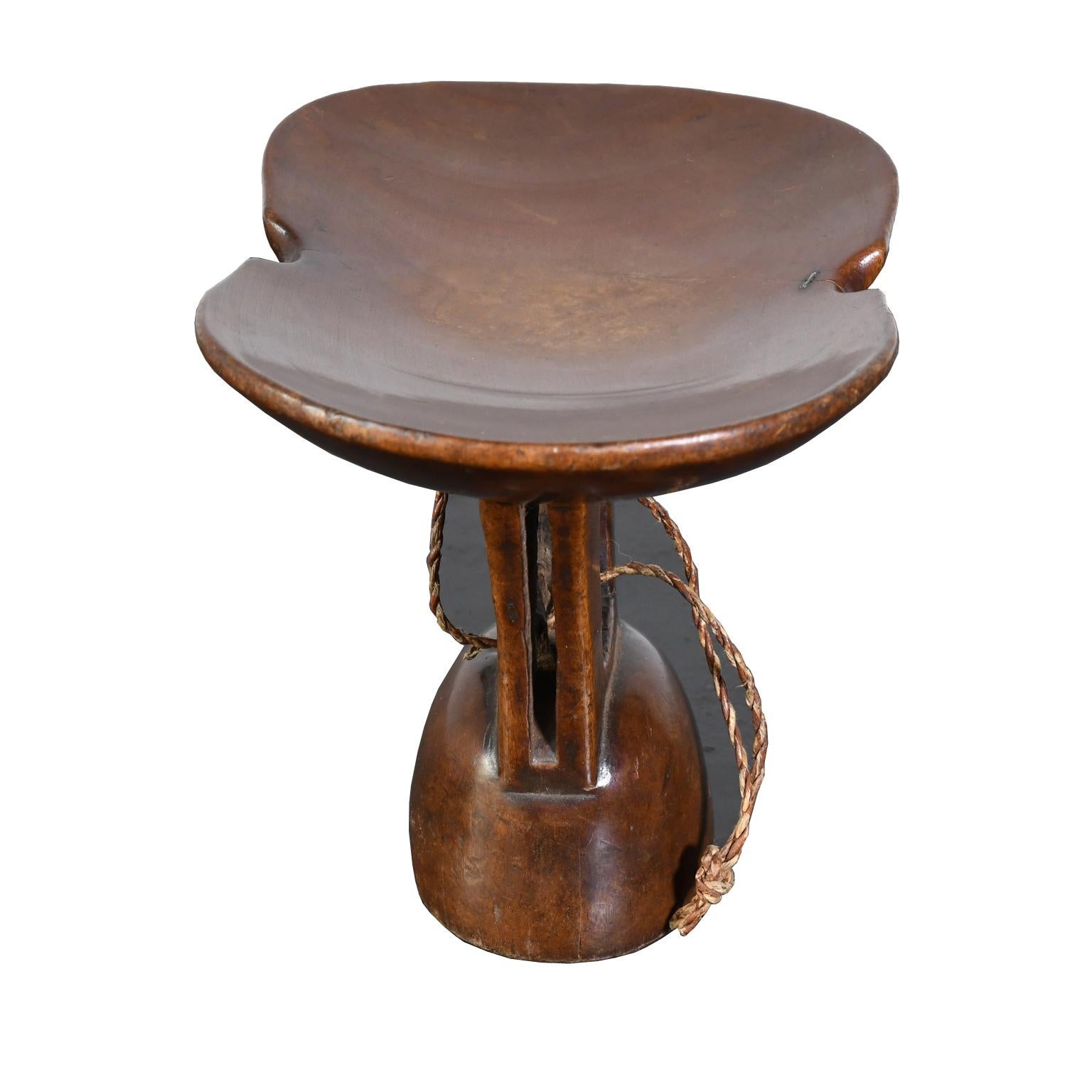 An Ethiopian headrest carved out of a single piece of wood in a medium chocolate-colored wood similar to walnut with a beautiful burnished patina. It was made as a utilitarian object for everyday use in tribal life (and not made as an artifact for