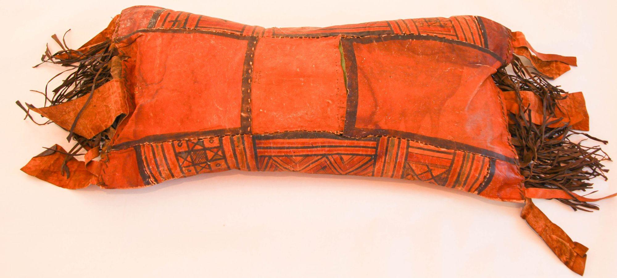 Large African Tuareg hand tooled leather pillow.
Great colors, hand painted with tribal geometric design with long leather fringes on each side.
Handcrafted in Africa with pieces of leather hand-sewn together and hand painted, the back has a