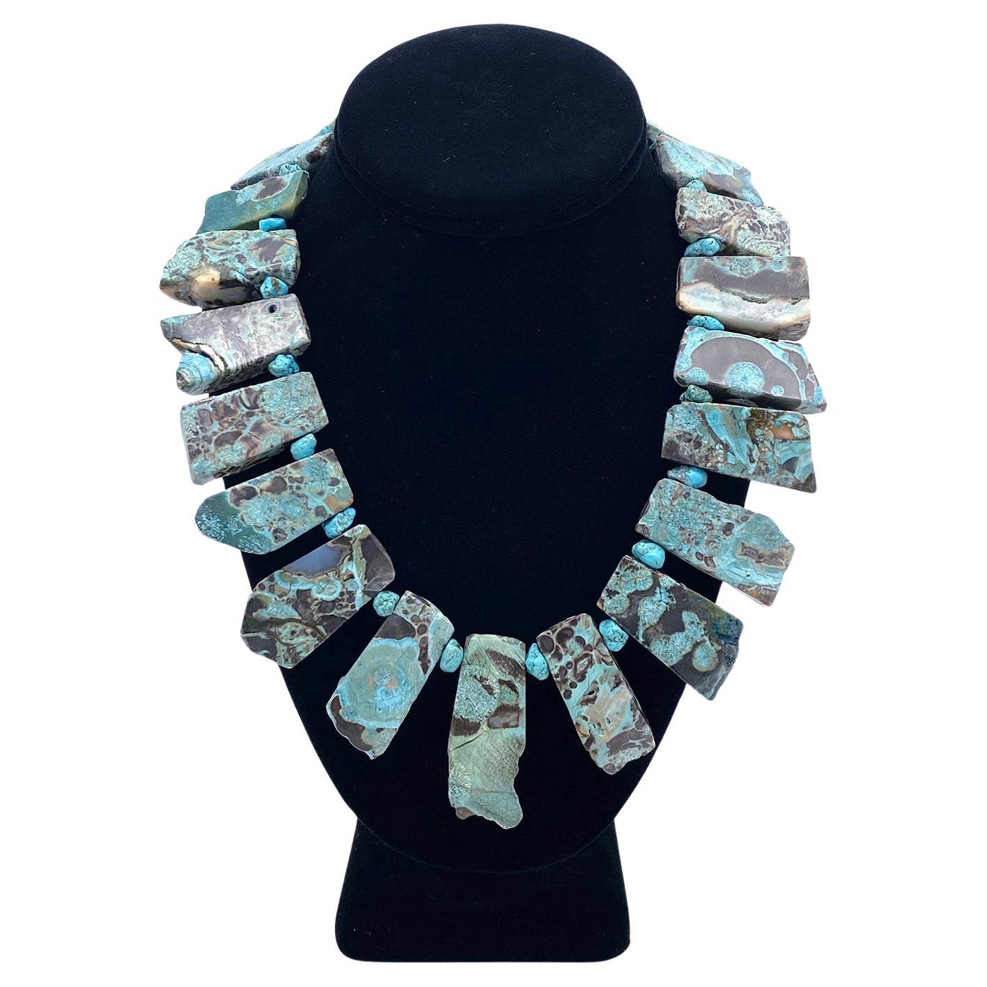 Questa è una collana realizzata con turchese africano. L'abbiamo creato con ventuno pietre turchesi graduate (da 1 a 2 pollici). Sono dotati di un lato grezzo e di un lato lucido, quindi è come se avessi due collane! La collana si collega con un