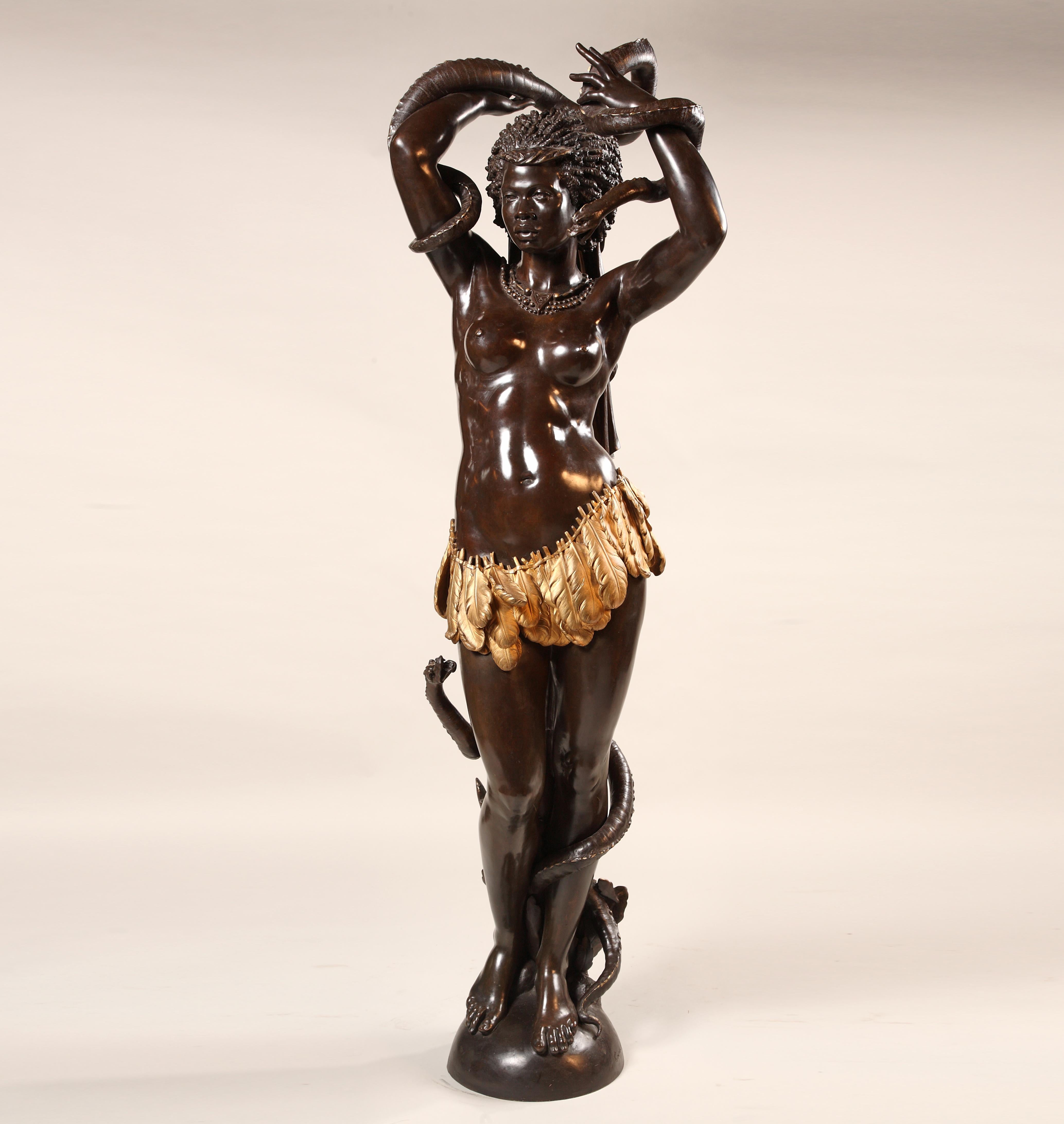 Eccezionale figura in bronzo a due patine, a grandezza naturale, raffigurante una giovane donna africana che doma un serpente, vestita con un perizoma piumato e un lungo drappo tra i capelli, e che indossa gioielli africani.

Un modello simile,