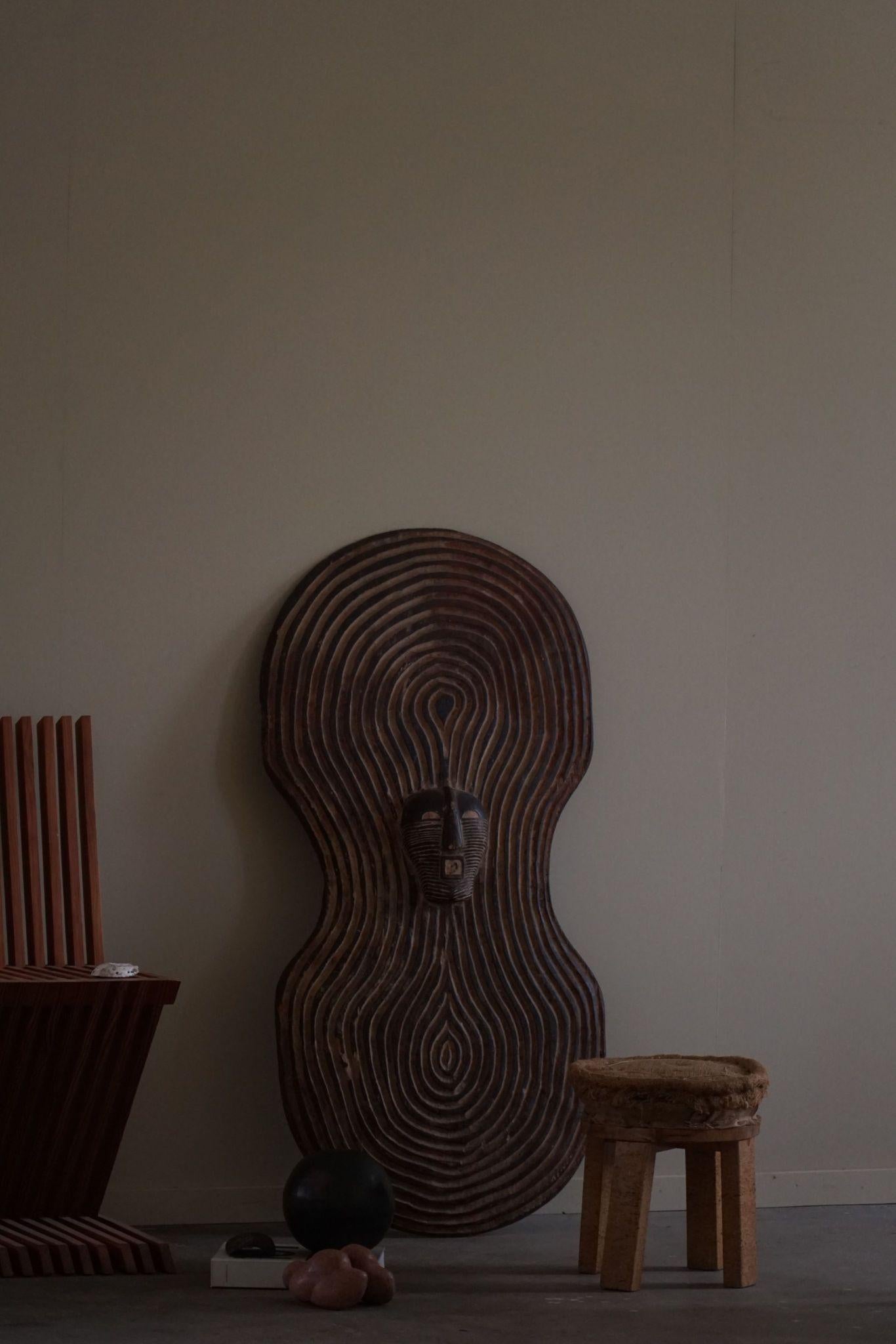 Das Songye-Schild ist ein eindrucksvolles Beispiel afrikanischer Stammeskunst aus dem Kongo, das aus der Mitte des 20. Jahrhunderts stammt. Dieser Schild, der vom Volk der Songye traditionell zum Schutz in kriegerischen und zeremoniellen Situationen