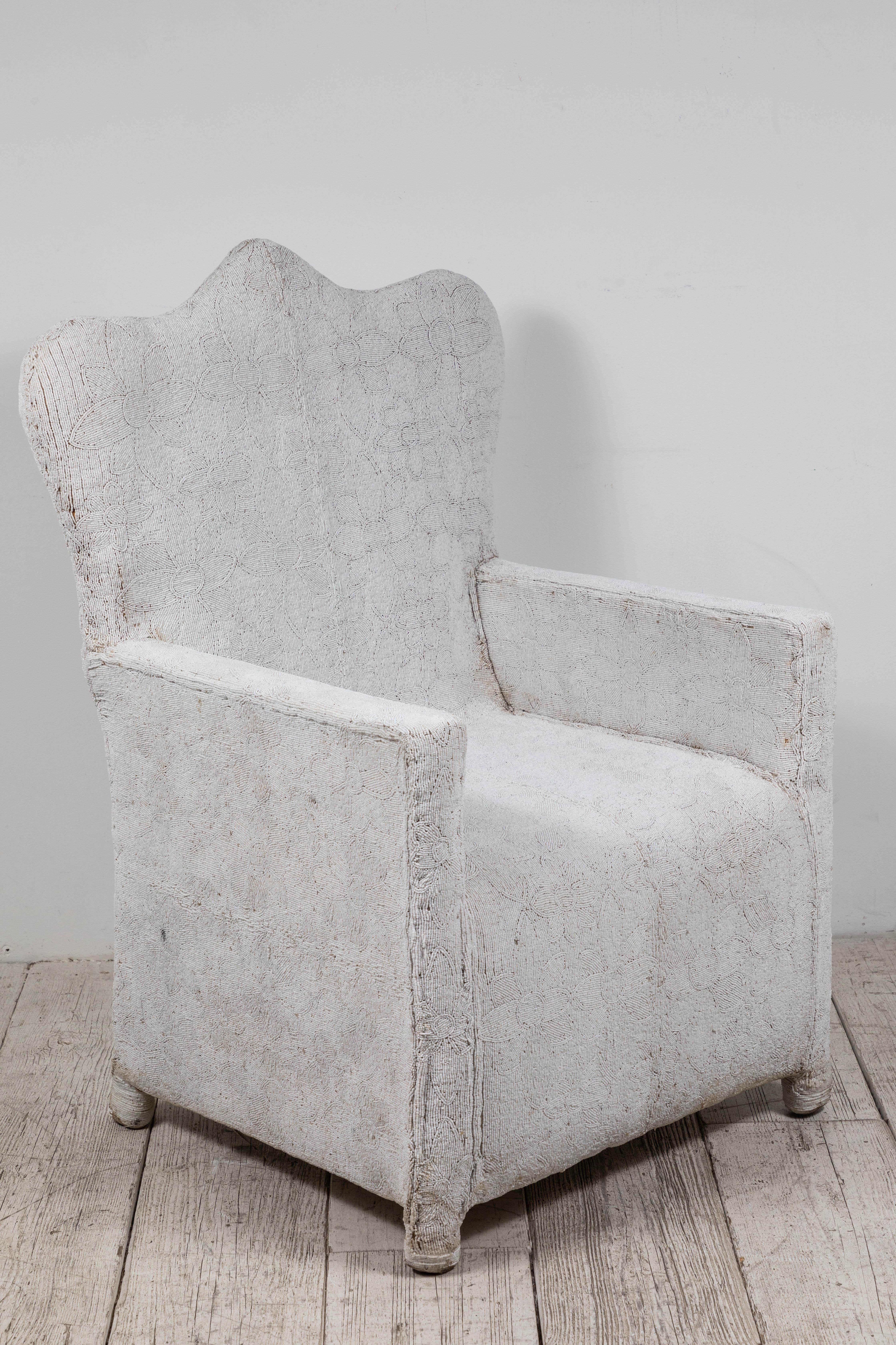 Rare African beaded chair from Nigeria. Meticulously assembled by hand in Nigeria using all white beads over a canvas and wood frame. Each chair is one-of-a-kind and exceptionally un-common.