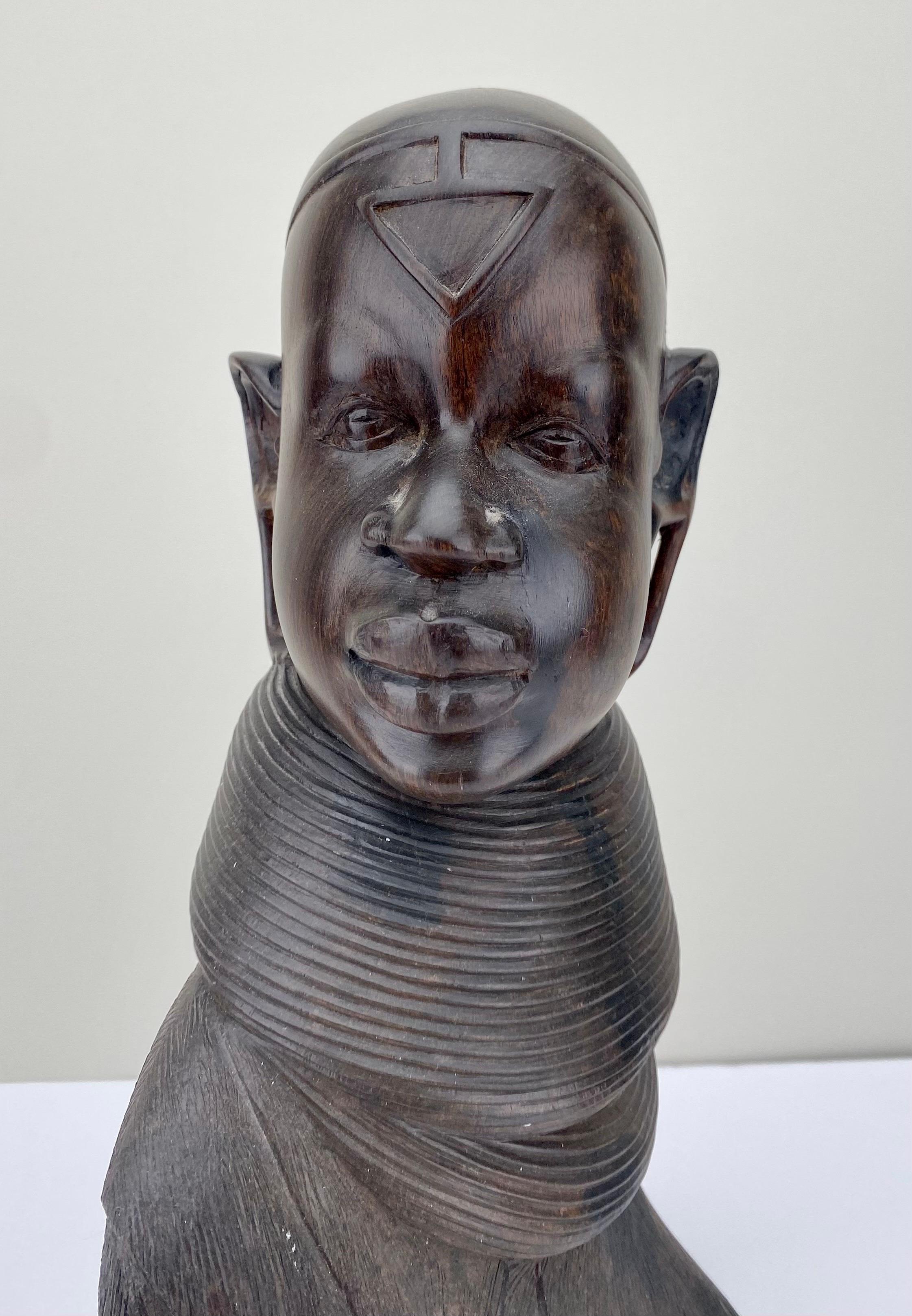  An African woman bust sculpture, meticulously hand-carved from the lustrous depths of ebony wood. This masterful creation pays homage to the rich heritage of African craftsmanship. 
The sculpture delicately unveils the intricate details of African